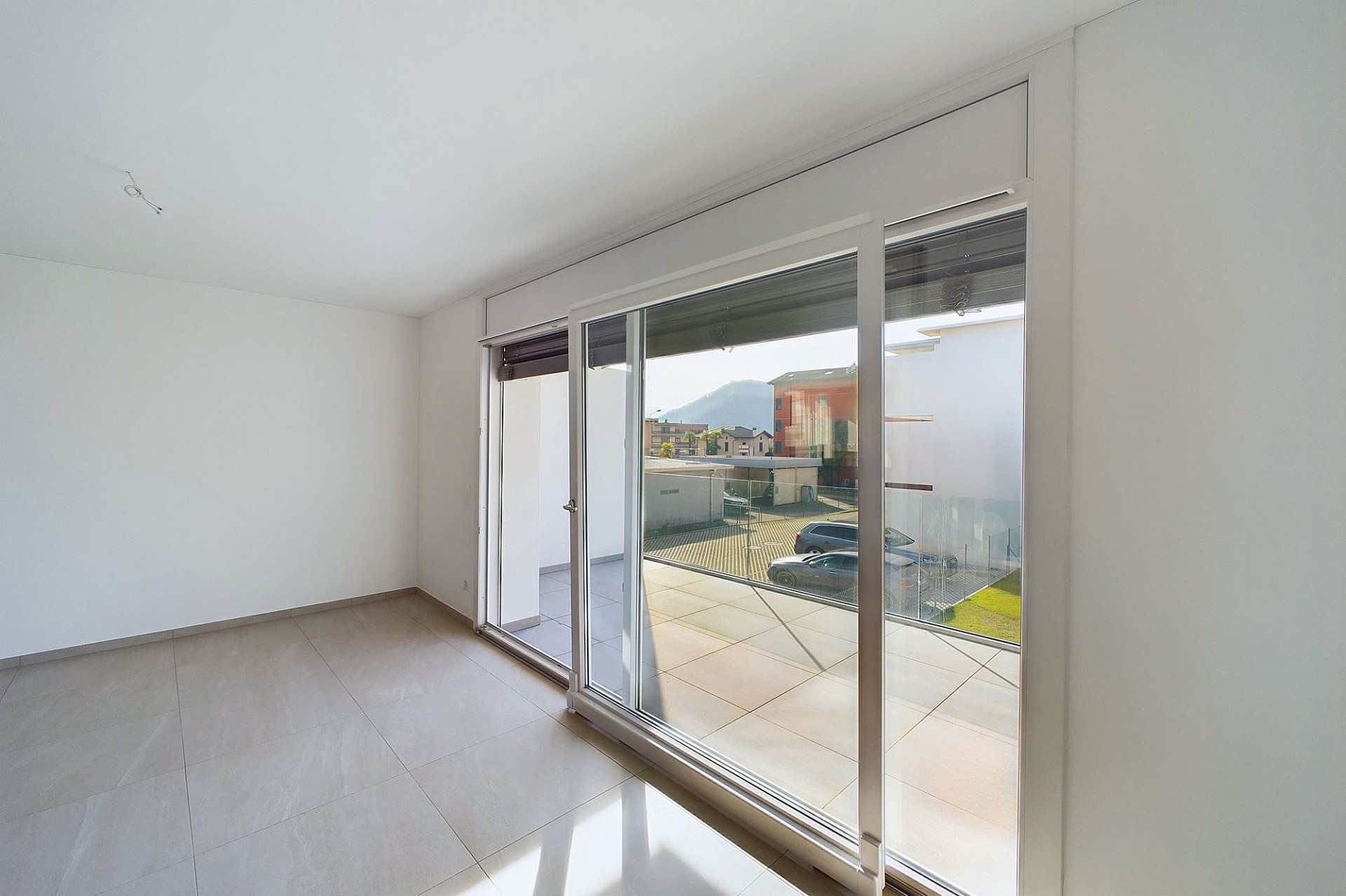 Heller leerer Raum mit großer Schiebetür zum Balkon
