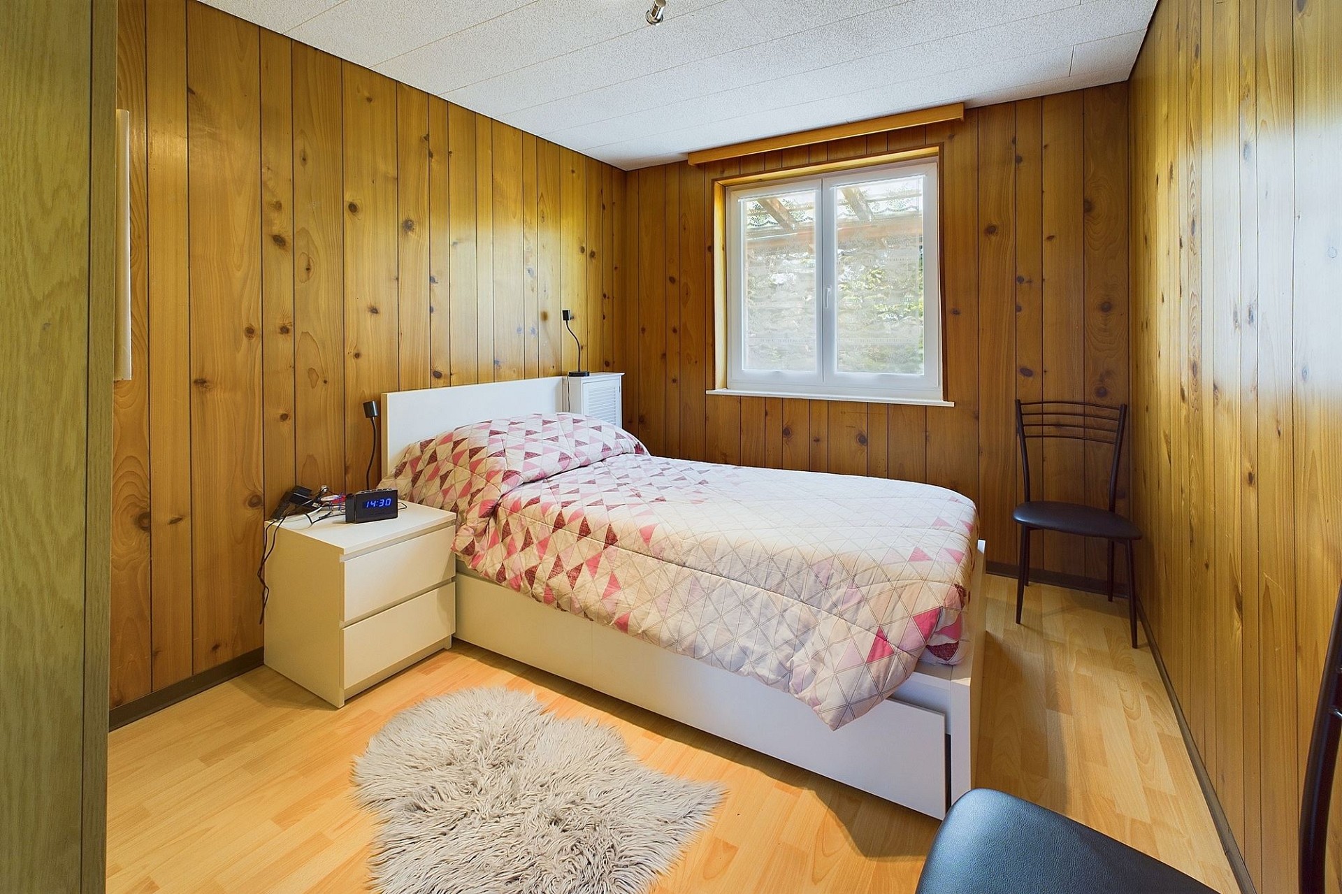 Kleines Schlafzimmer mit Holzvertäfelung