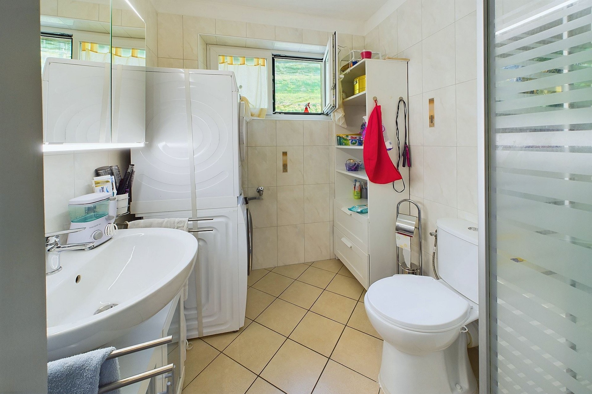 Kleines Badezimmer mit Waschtisch, WC und Glasdusche