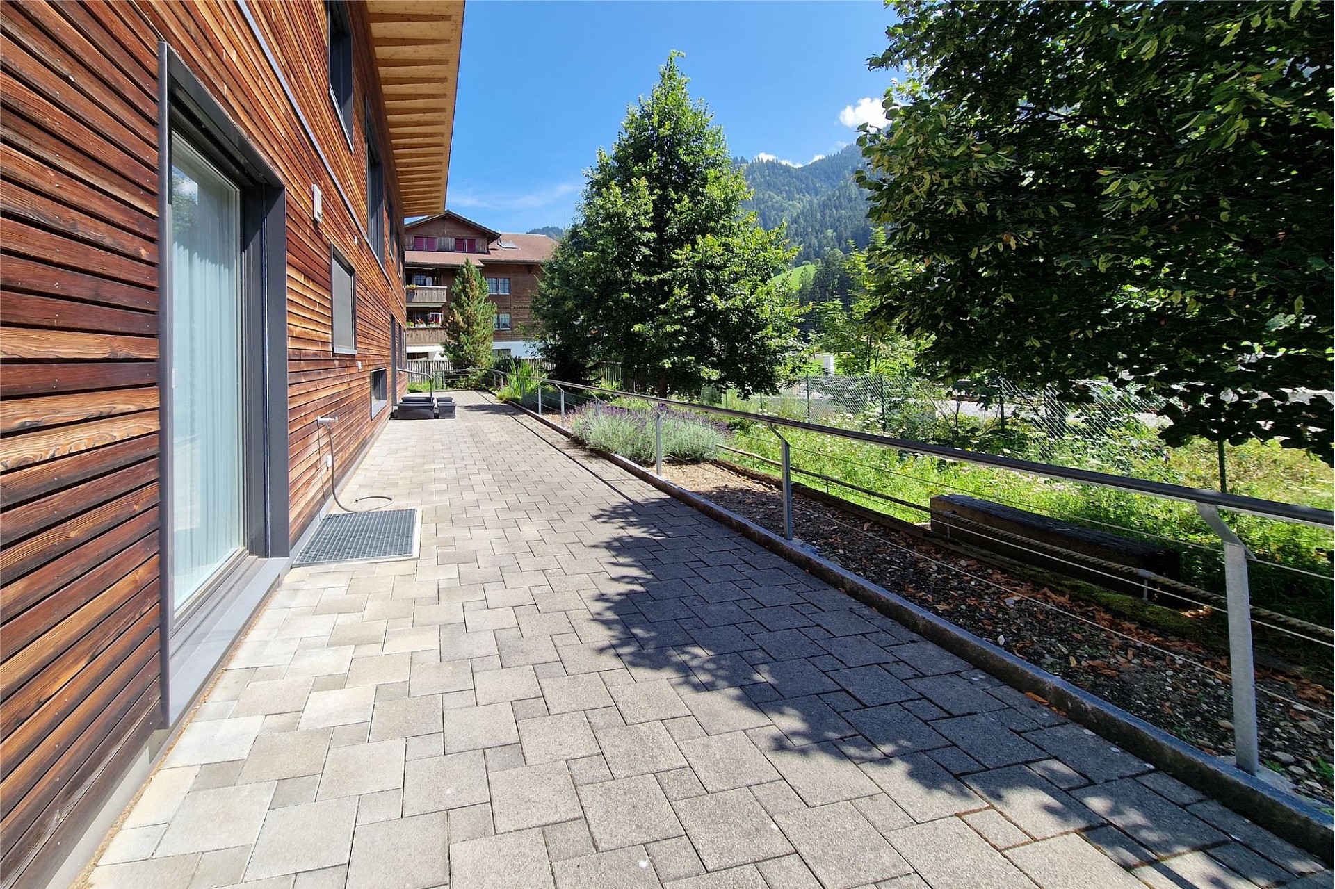 Außenweg entlang eines Holzgebäudes mit Bergblick