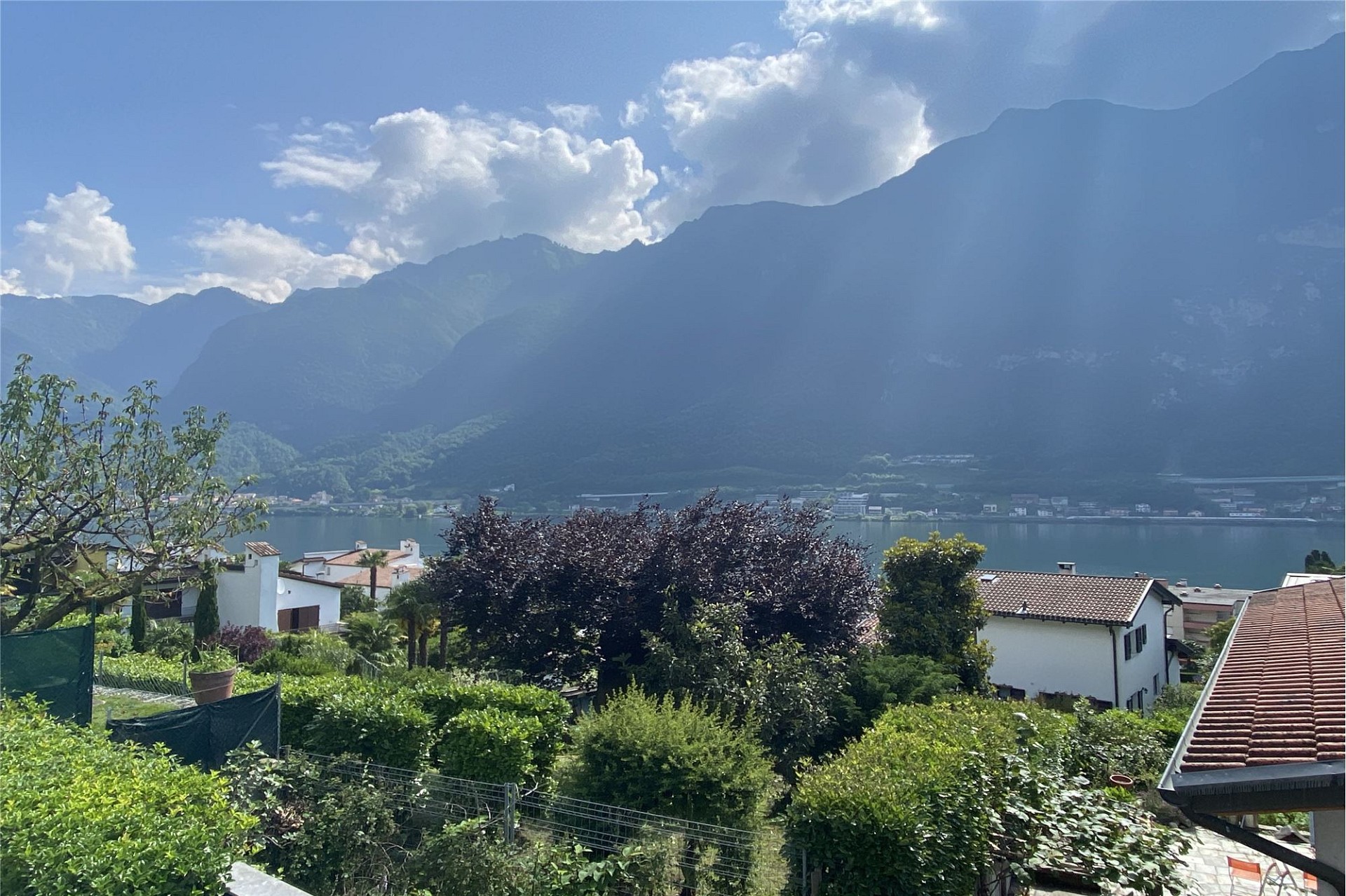 Seeblick mit Bergen und Wohnhäusern
