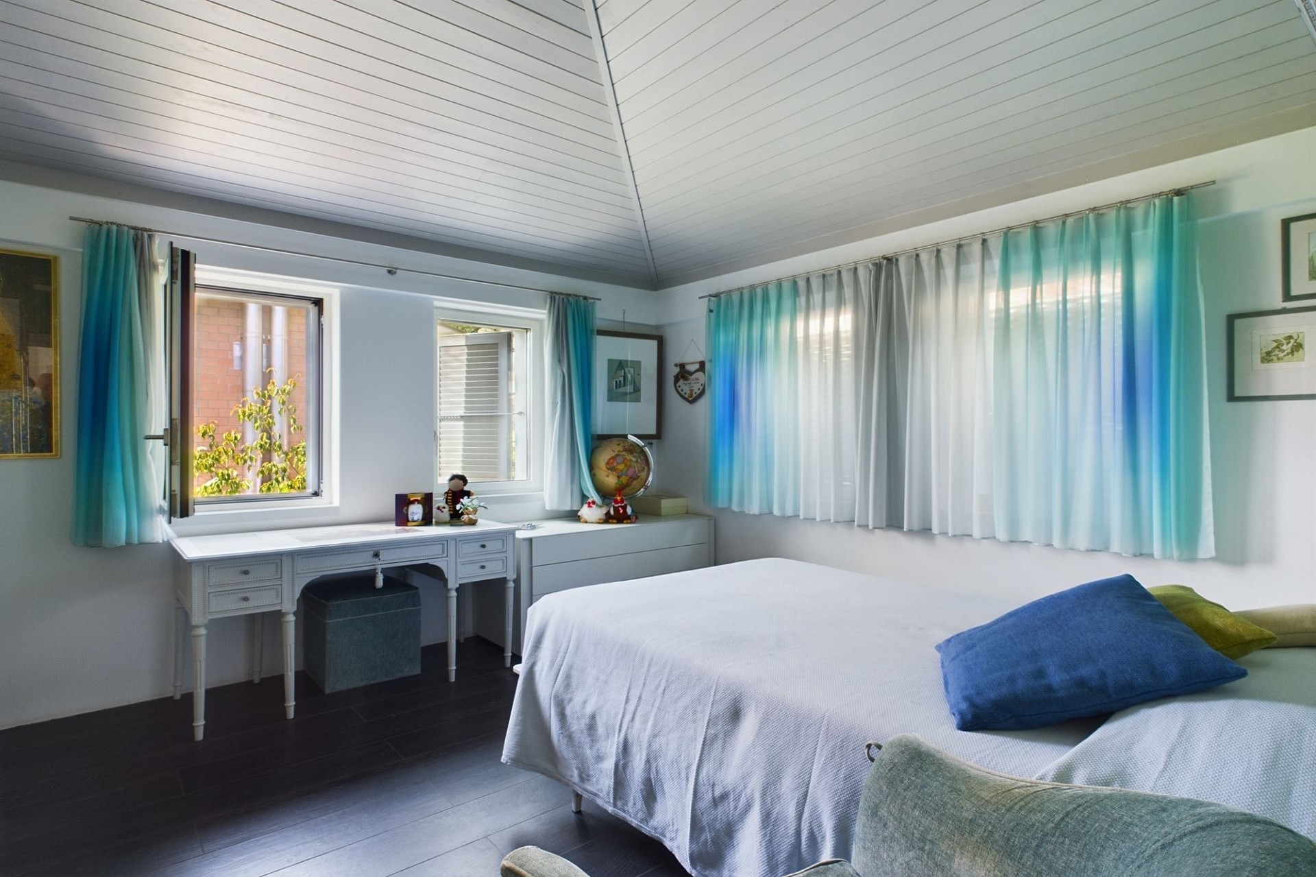 Helles Schlafzimmer mit großen Fenstern und heller Einrichtung