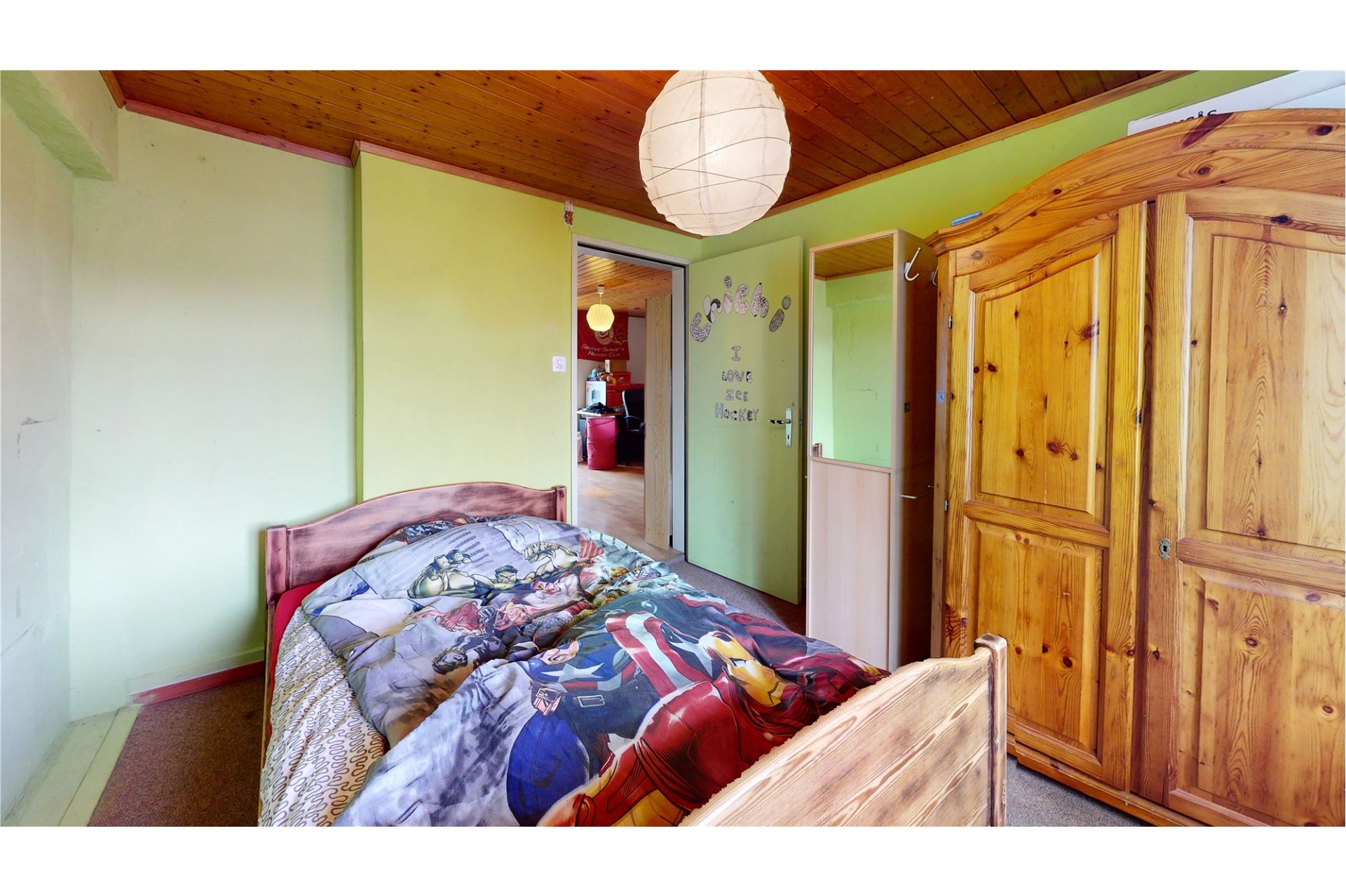 Jugendzimmer mit Holzdecke und Kleiderschrank