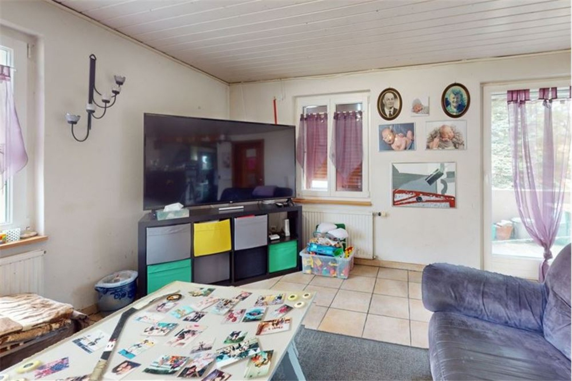 Wohnzimmer mit TV-Wand und Terrassezugang