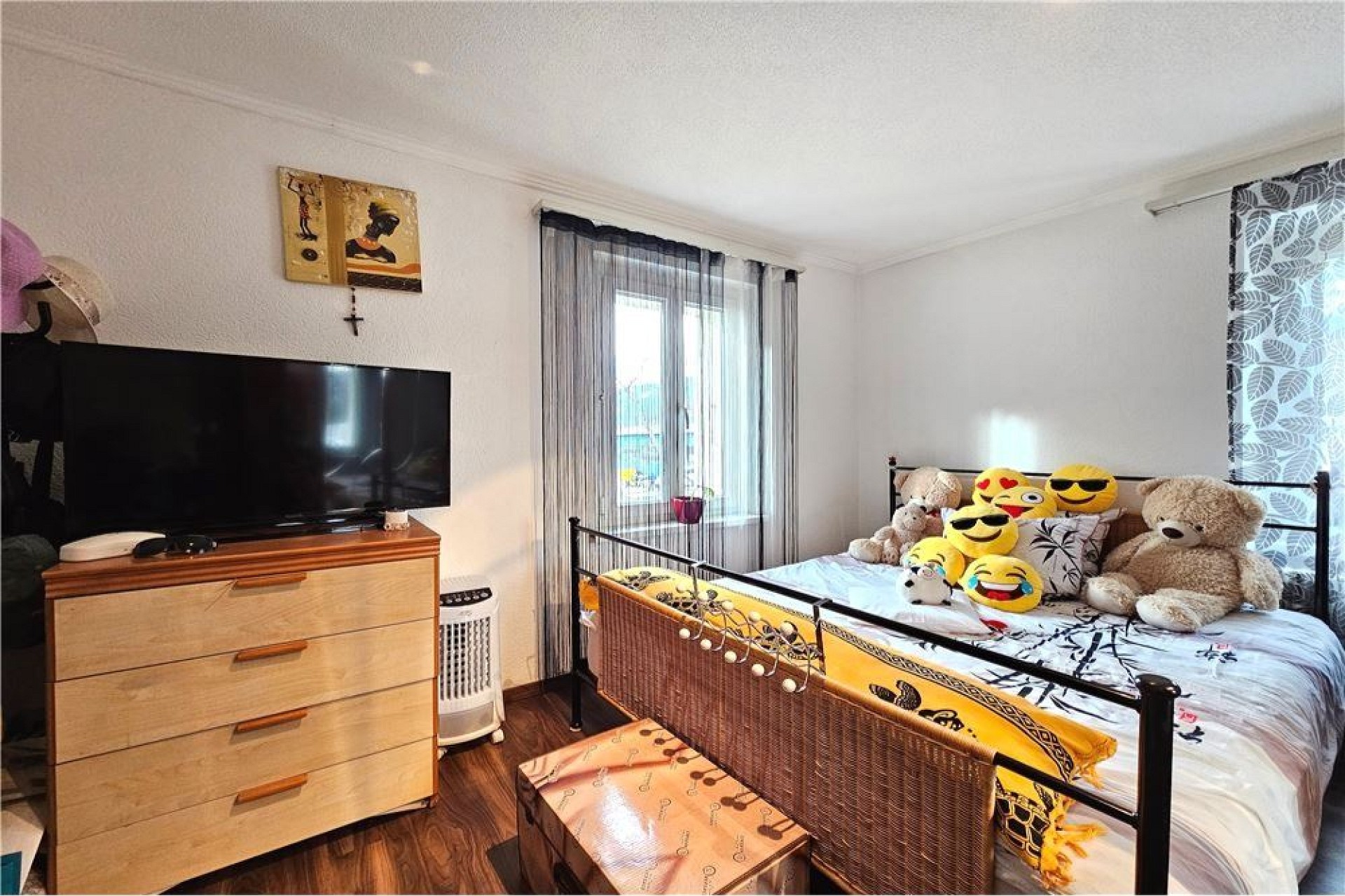 Gemütliches Schlafzimmer mit Doppelbett und Fernseher