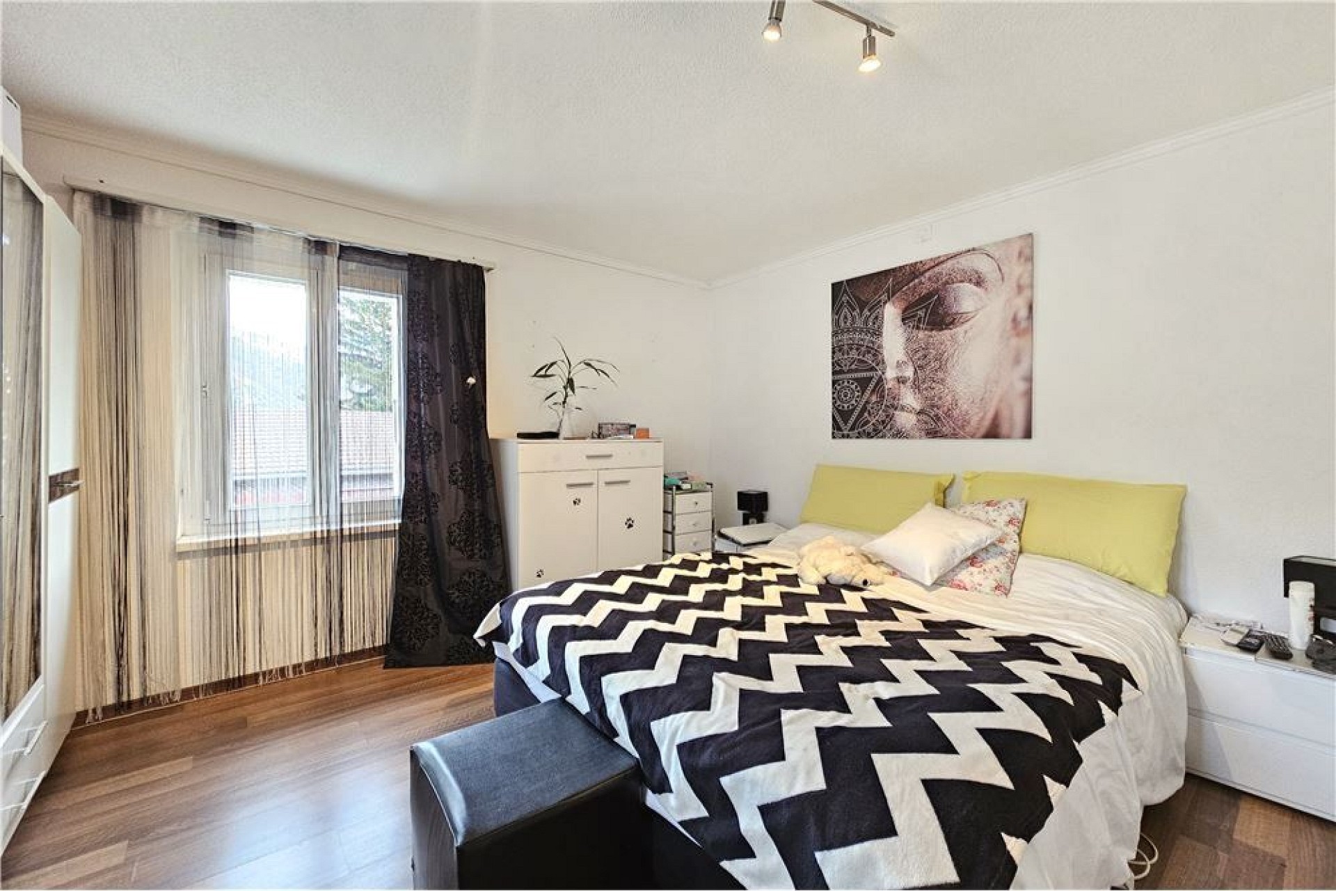 Helles Schlafzimmer mit Bett und Fensterfront