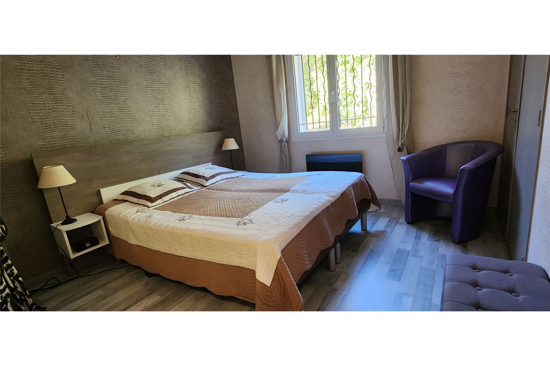 Gemütliches Schlafzimmer mit Doppelbett und Fenster