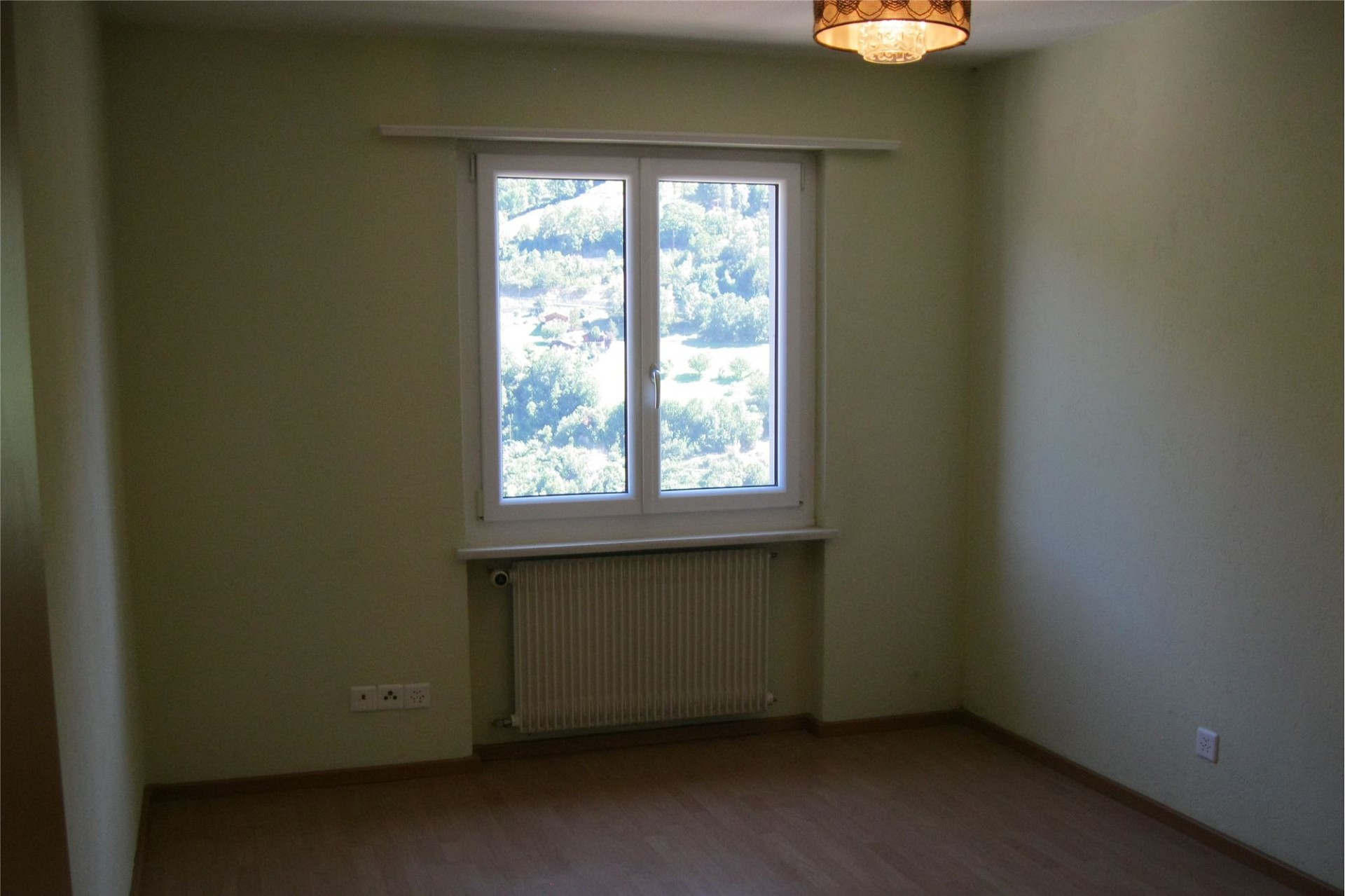 Leeres Zimmer mit Fenster und Heizkörper
