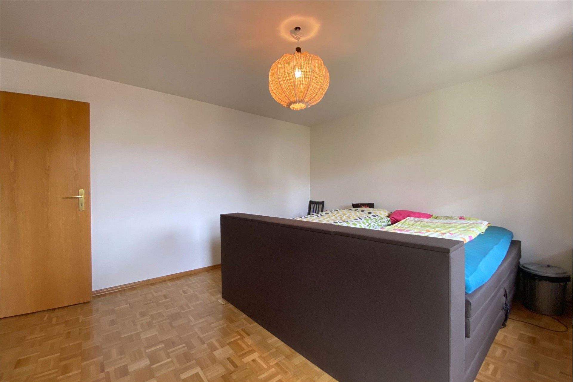 Schlafzimmer mit Parkettboden und Einzelbett