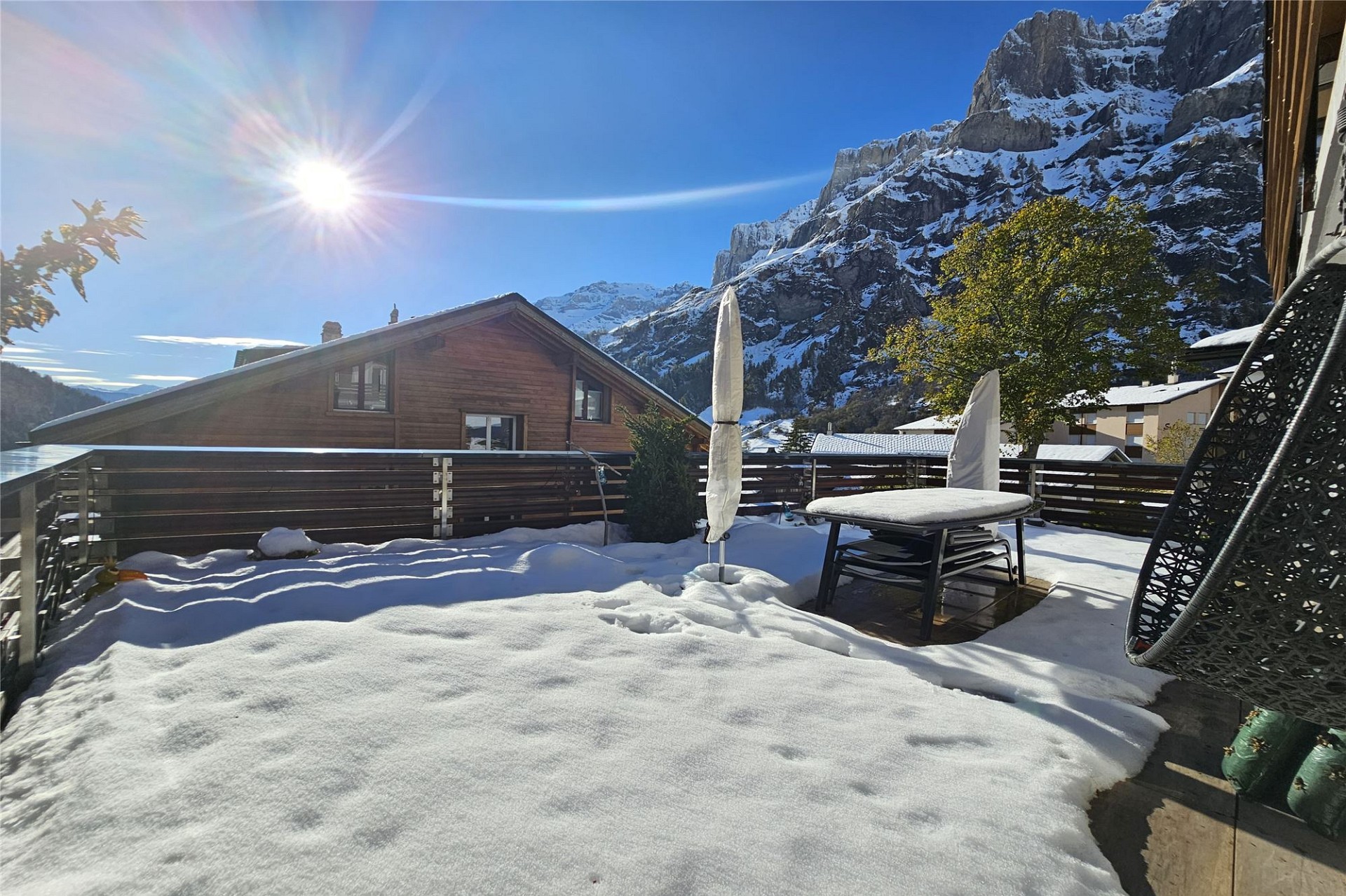 Sonnige Bergterrasse mit Schnee und Alpenblick