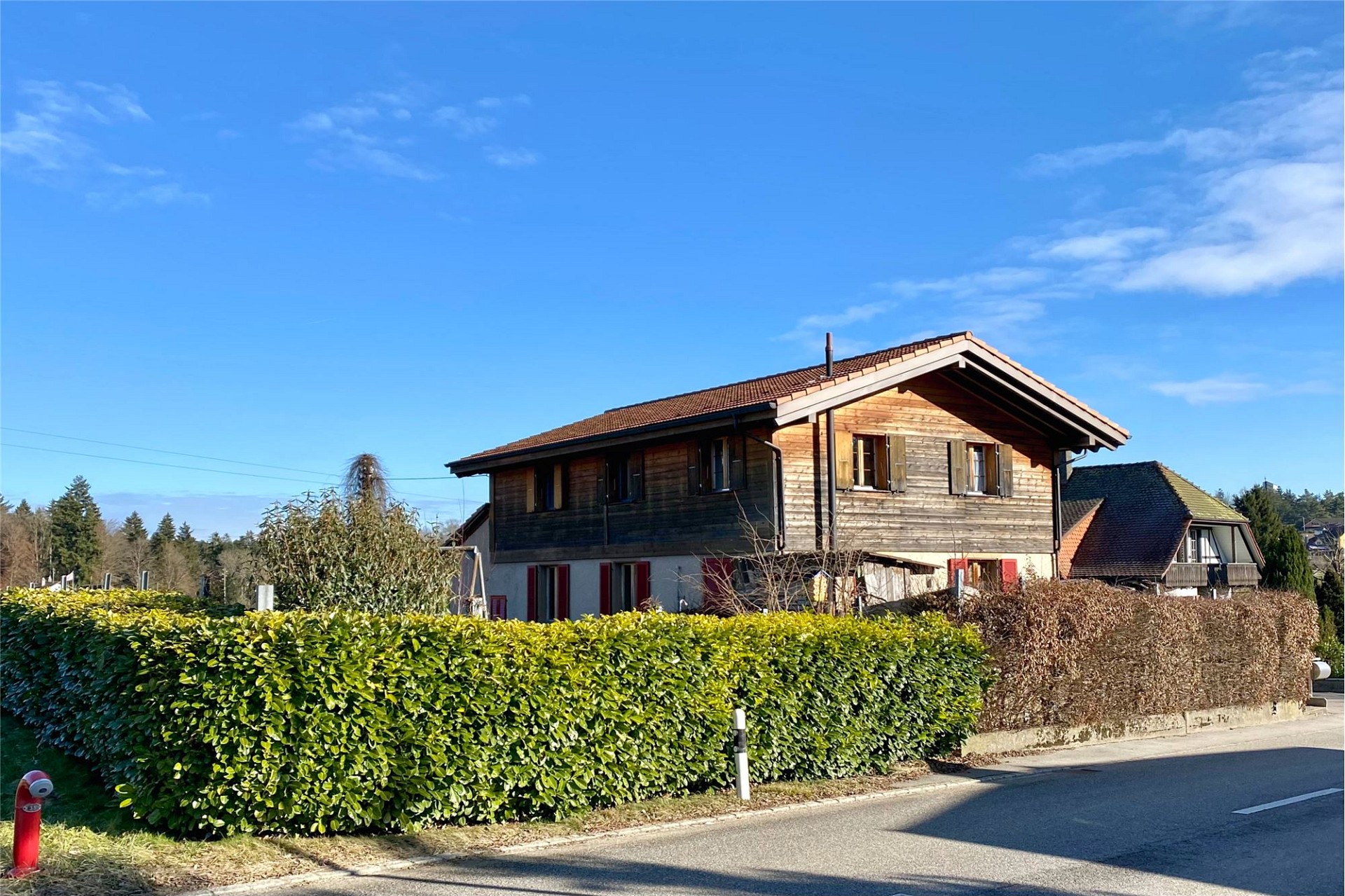 Alpines Holzhaus mit Garten und Hecke