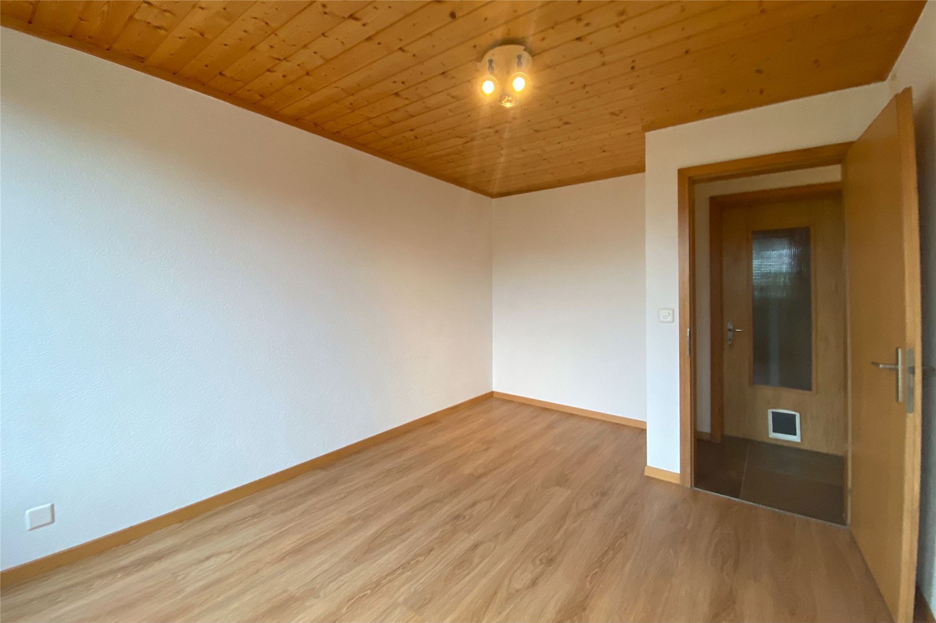 Leerer Raum mit Holzdecke und Holzboden