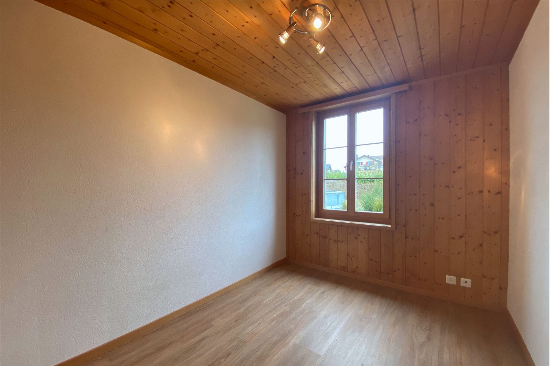 Heller leerer Raum mit Holzverkleidung und Fenster