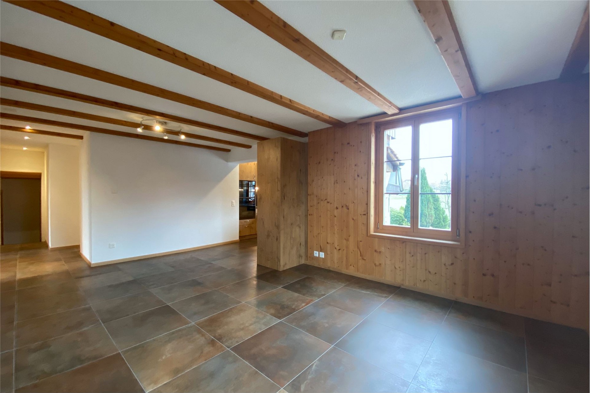 Heller Wohnraum mit Holzdecke und Fliesenboden