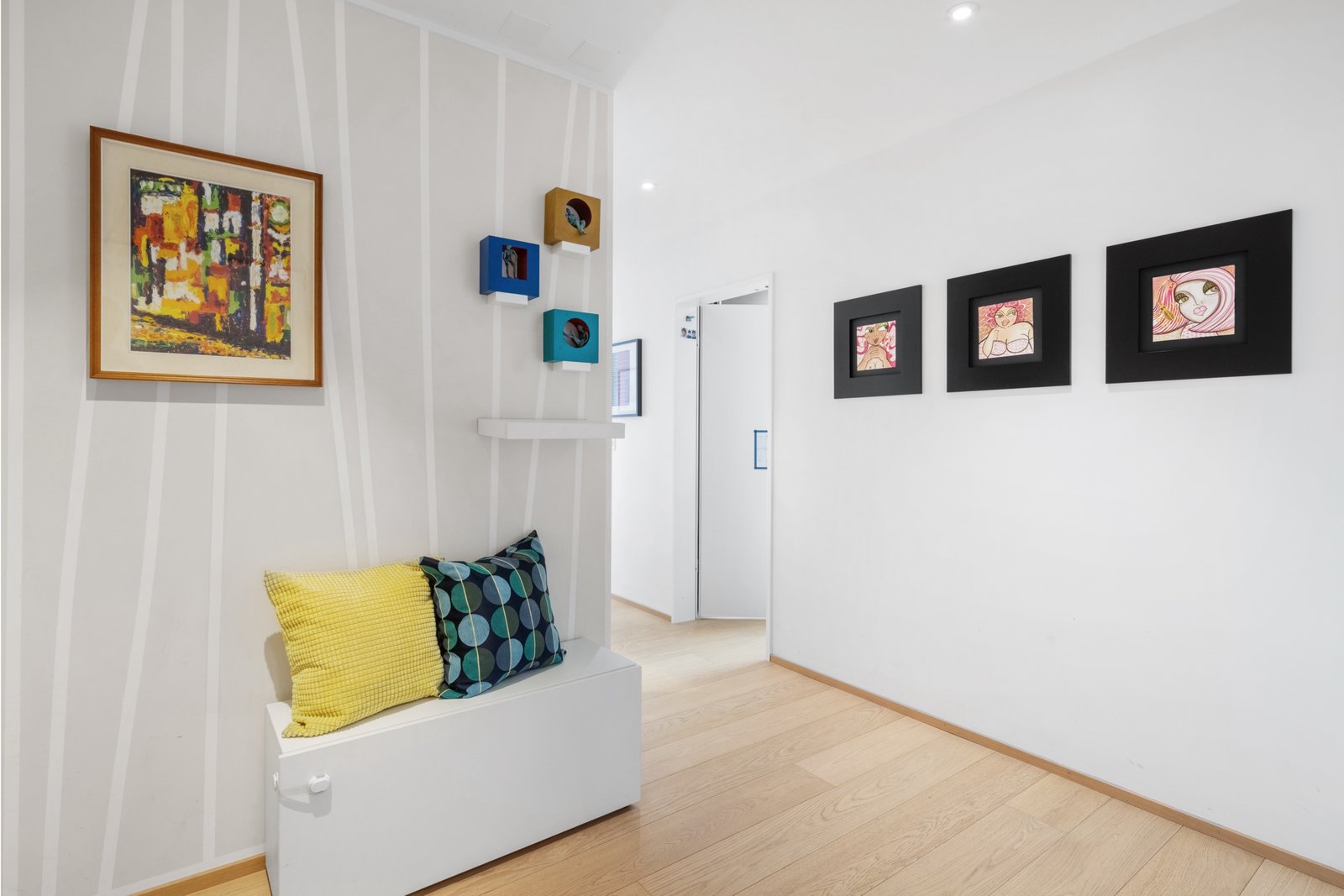 Heller Flur mit Kunst und Sitzbank