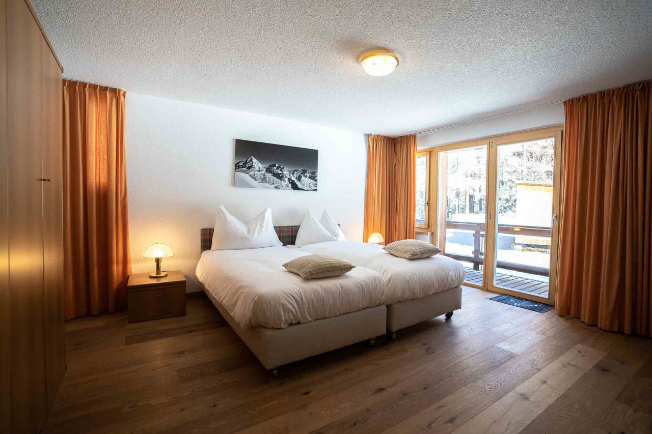 Helles Schlafzimmer mit Doppelbett und Balkonzugang