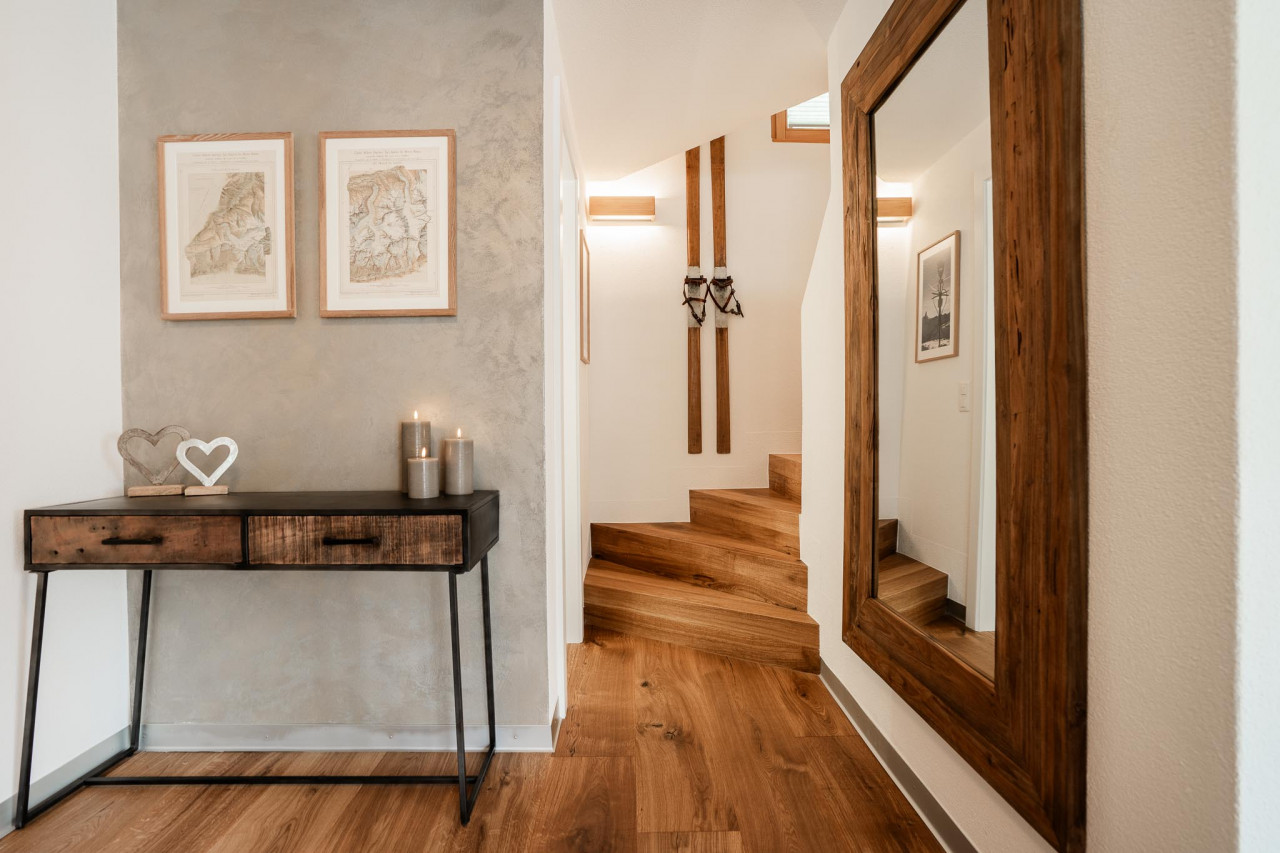 Heller Flur mit Holztreppe und Spiegel