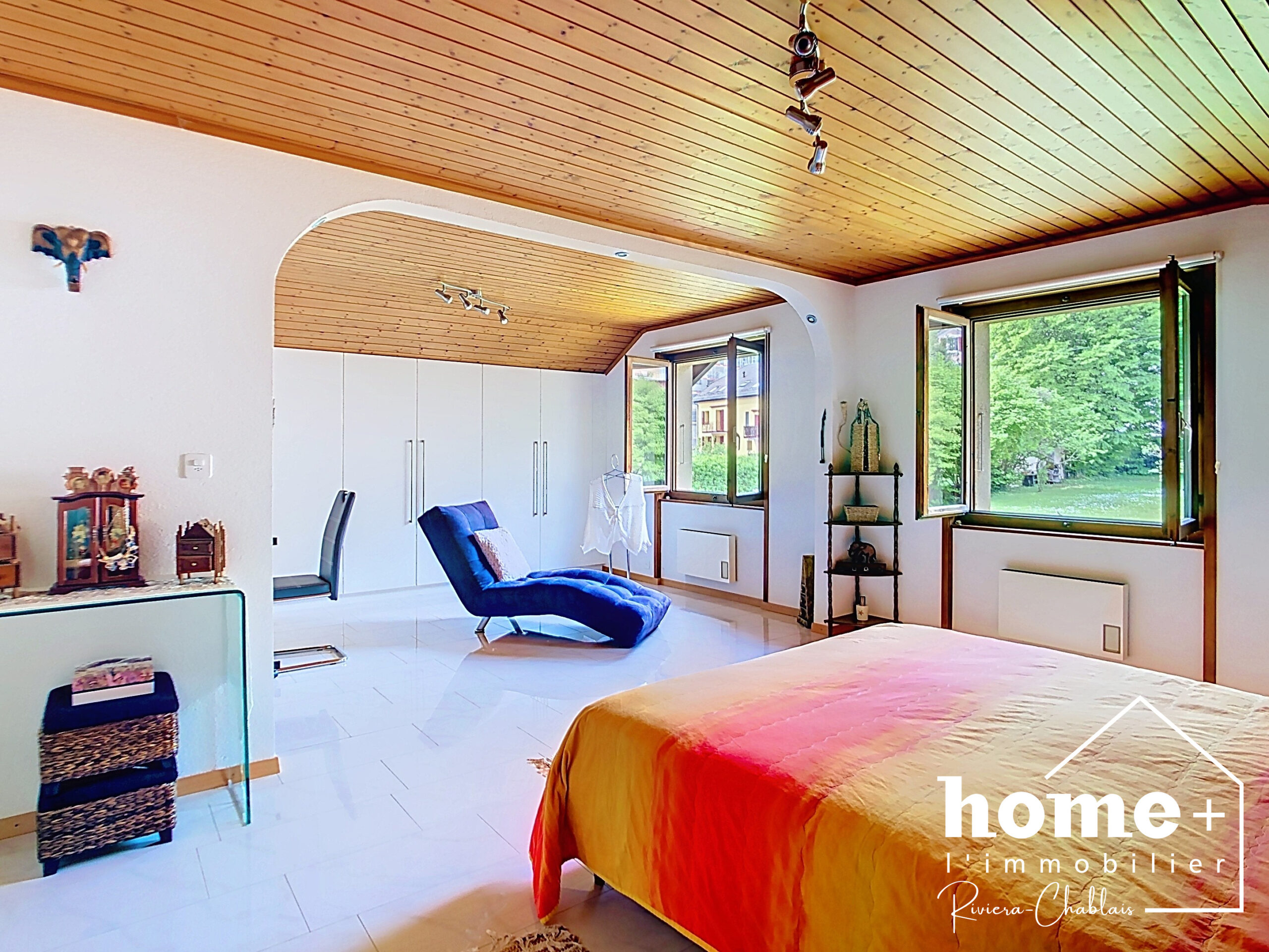 Helles Schlafzimmer mit Holzdecke und Blick ins Grüne