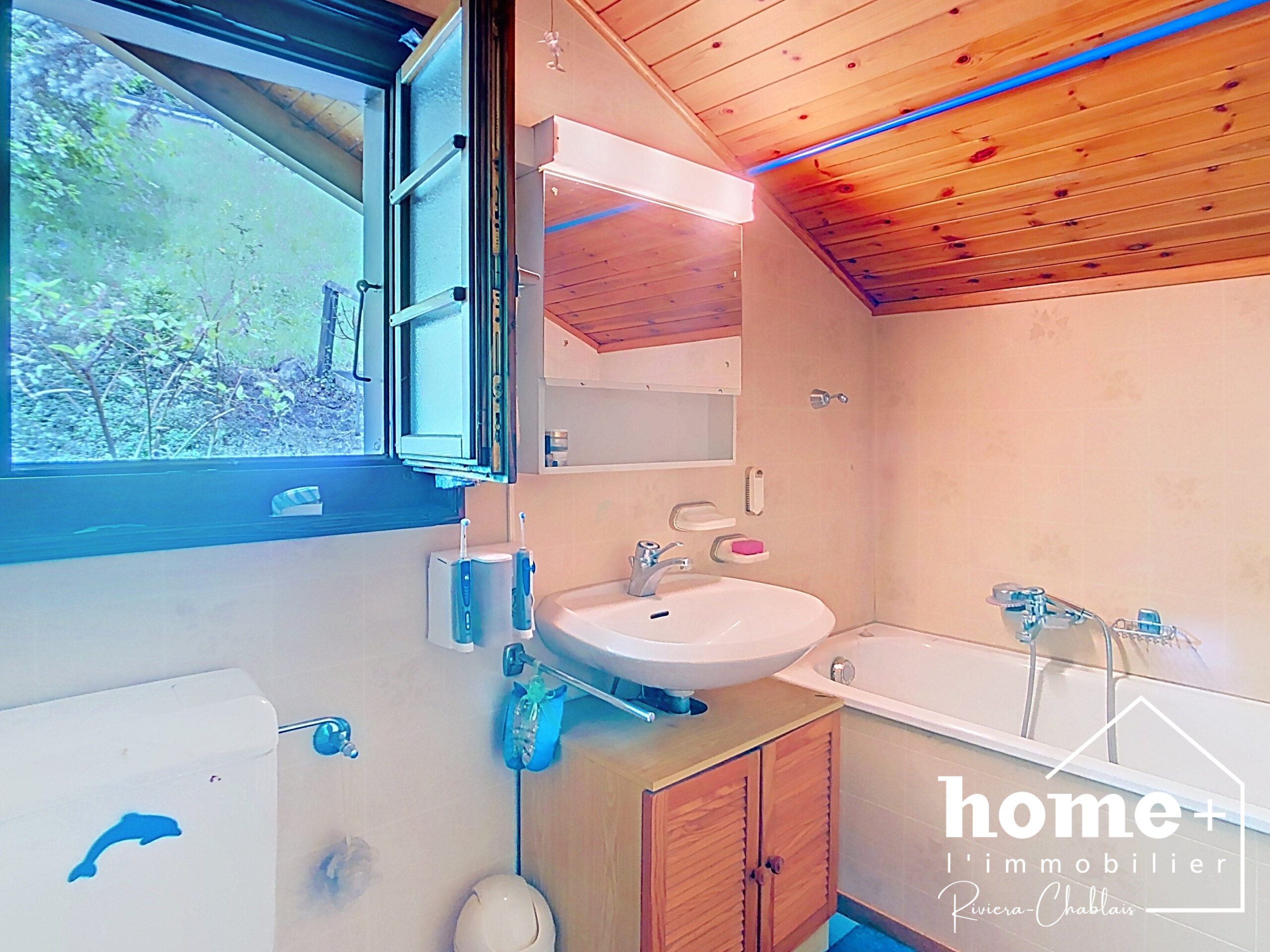 Kleines Badezimmer mit Holzdecke und Außenfenster
