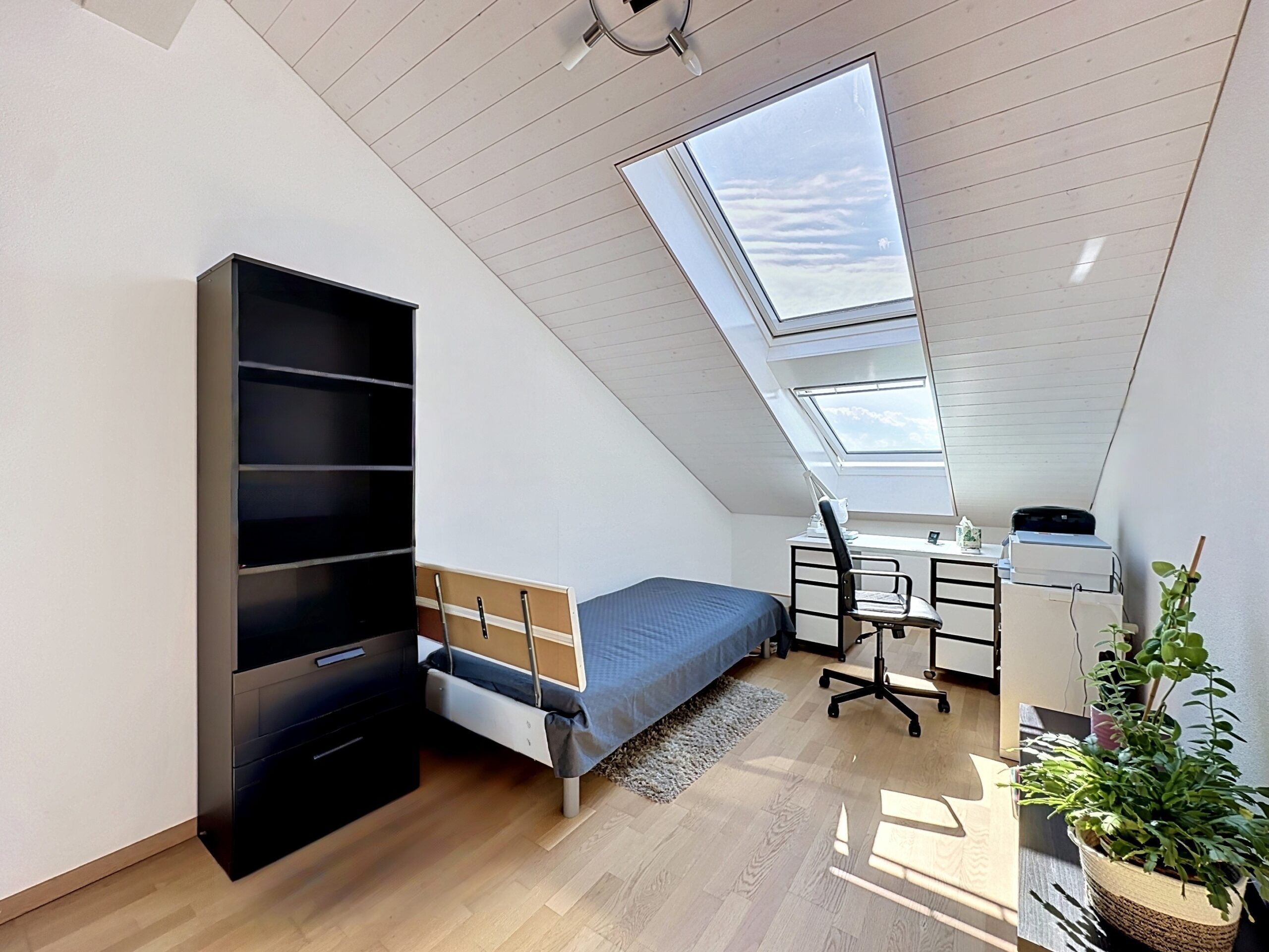 Helles Dachzimmer mit Einzelbett und Arbeitsplatz