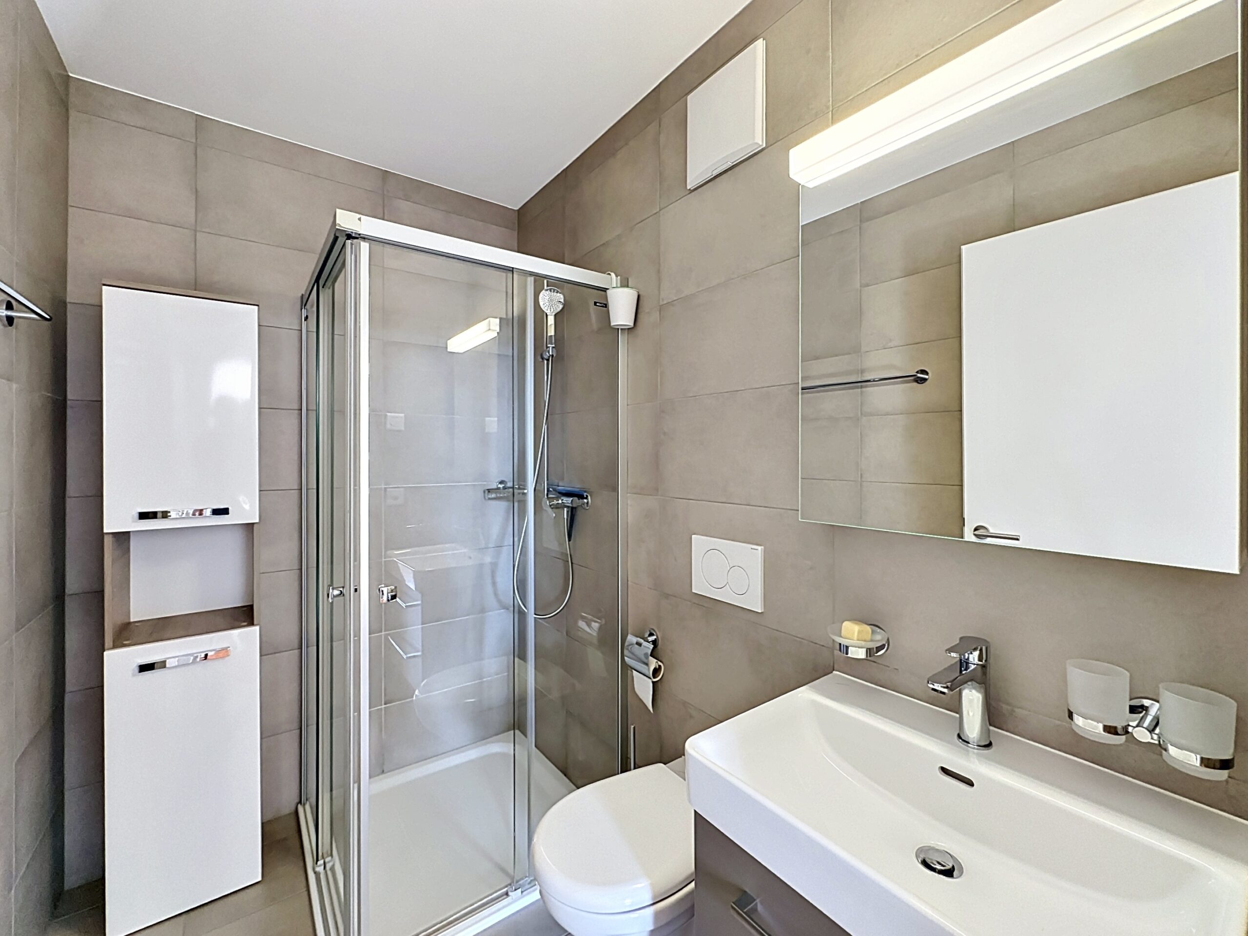 Modernes Badezimmer mit Dusche, Waschbecken und WC
