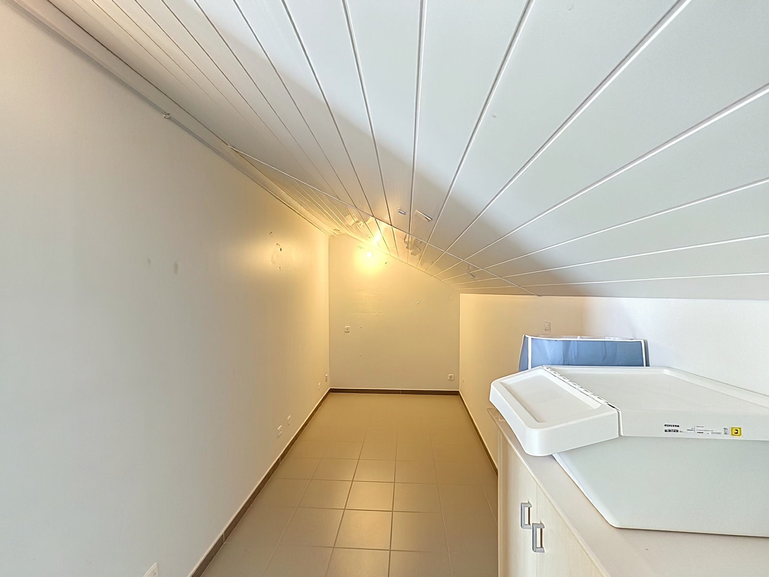 Dachgeschossraum mit schräger Decke und Technikgerät