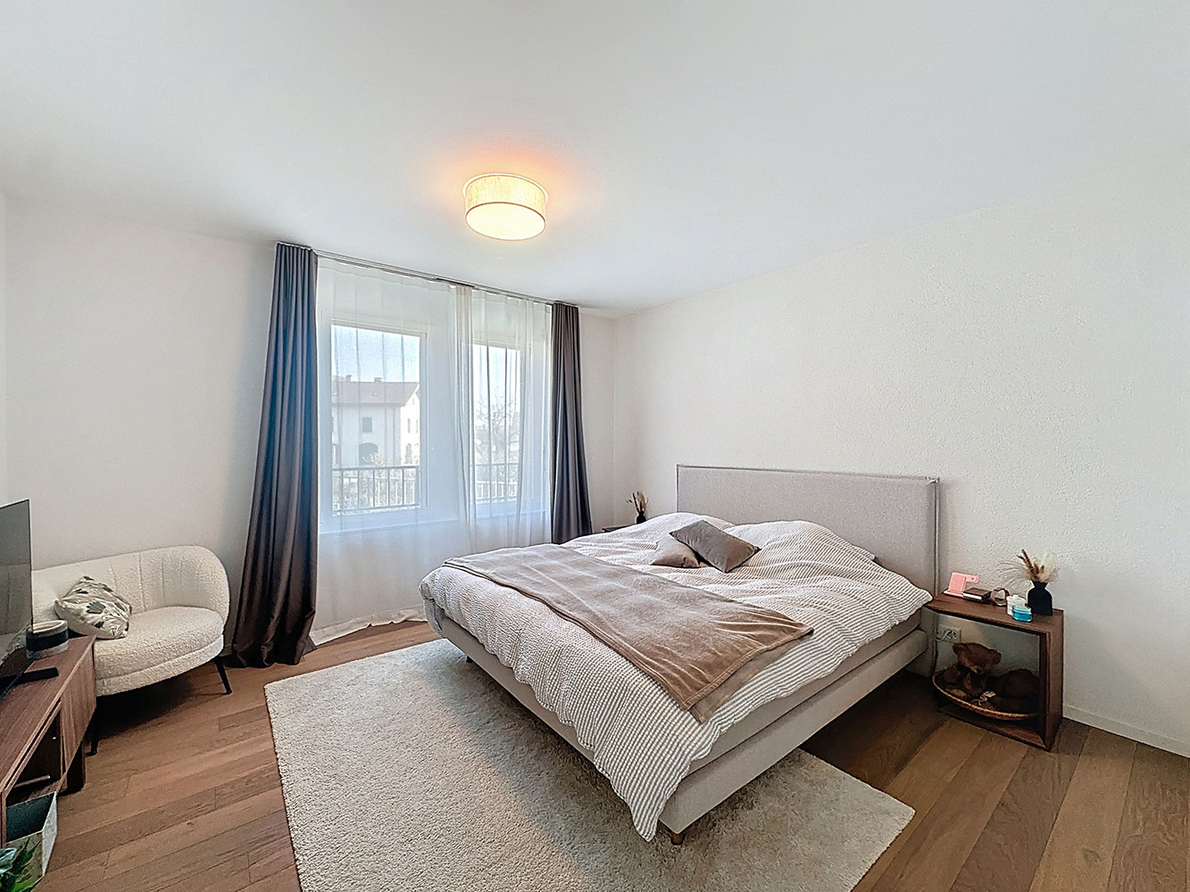 Schlafzimmer mit Doppelbett und großem Fenster