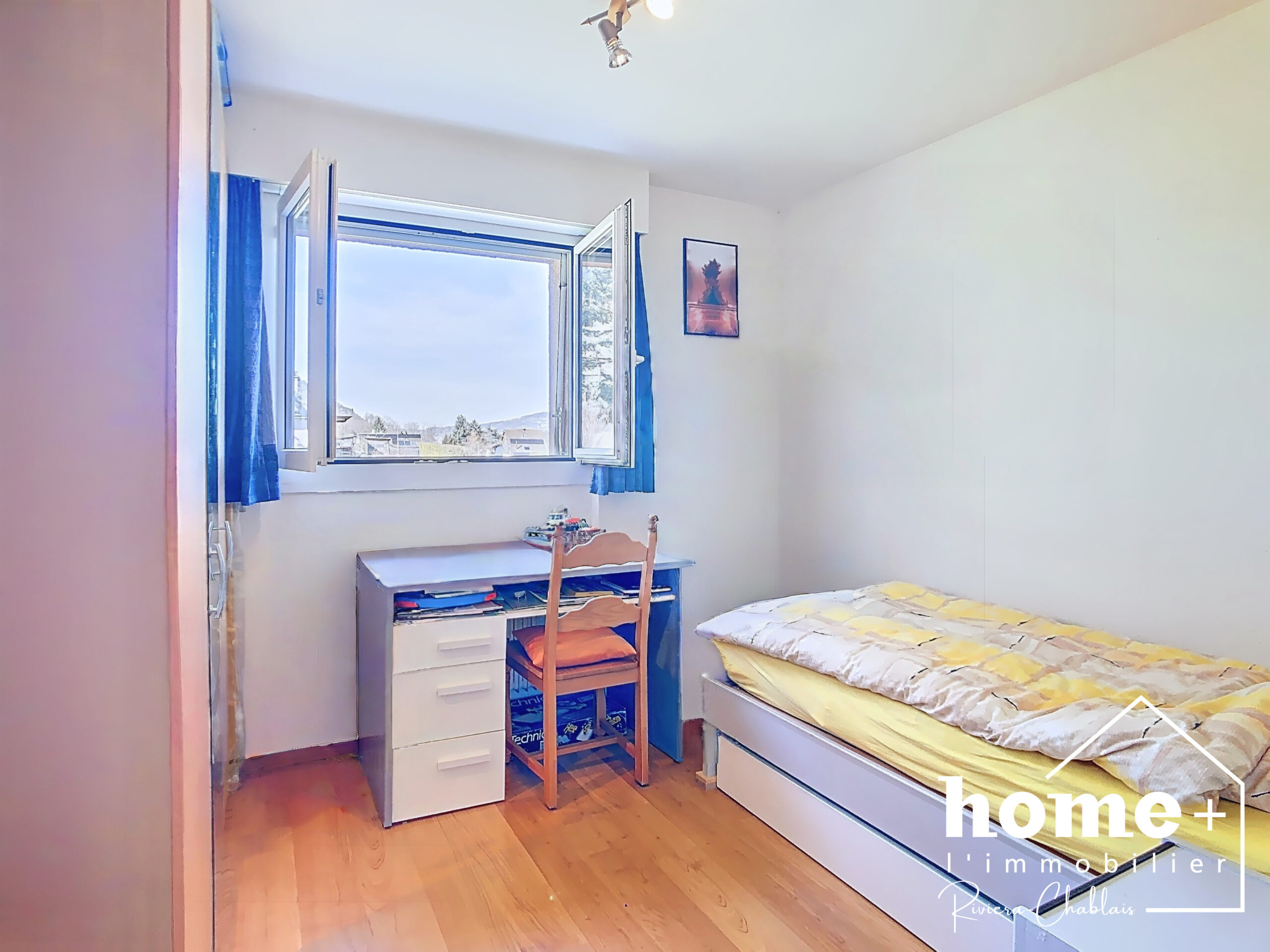 Helles Schlafzimmer mit Schreibtisch und Fensterblick
