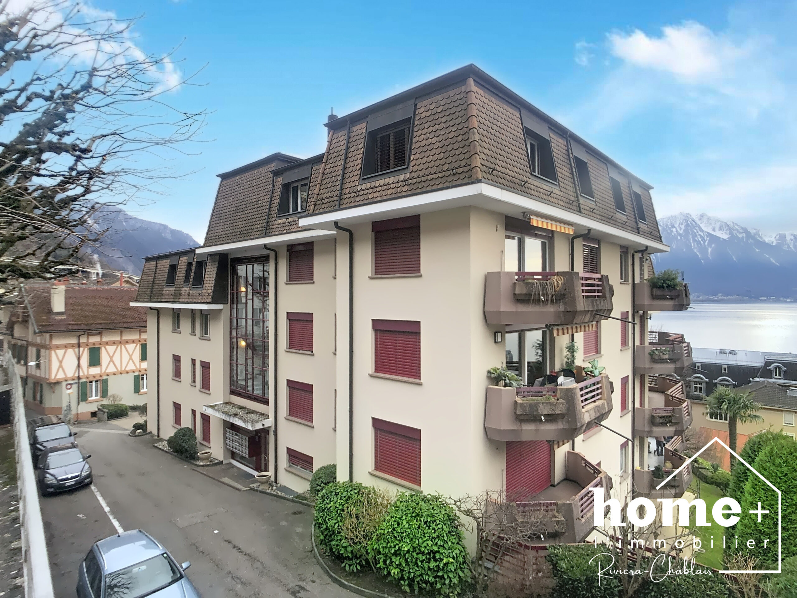 Außenansicht eines Mehrfamilienhauses mit Seeblick und Bergen