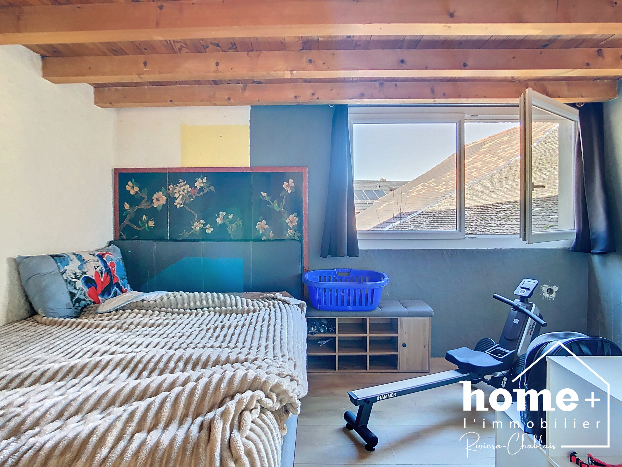 Schlafzimmer mit Dachbalken und offenem Fenster