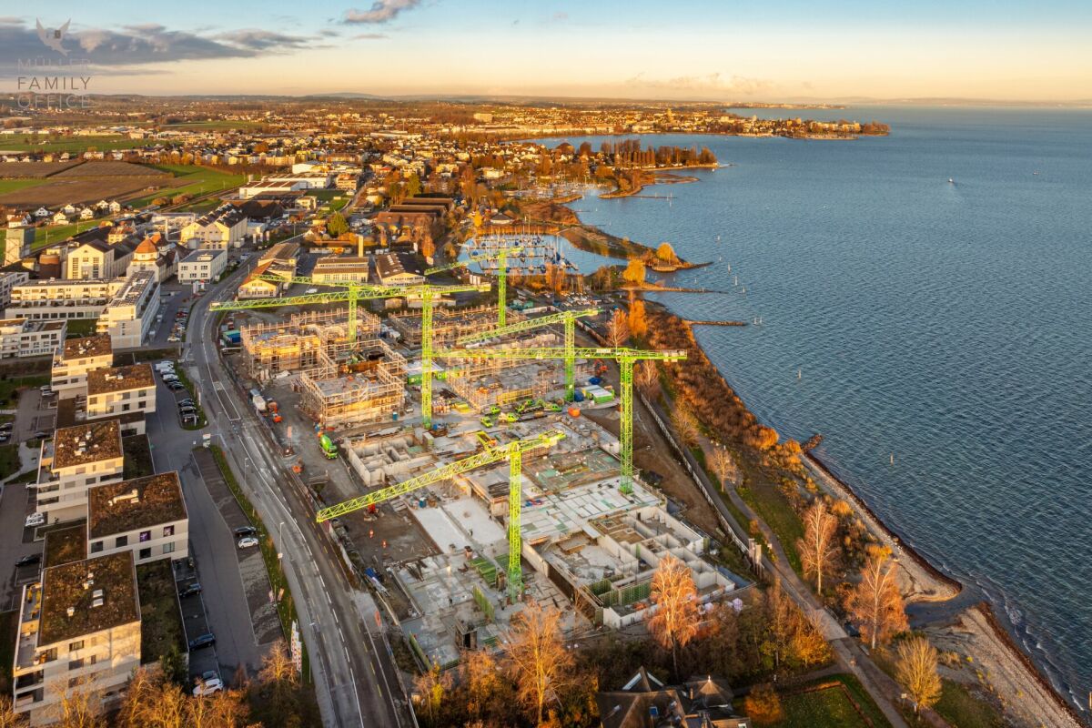 Luftaufnahme einer Küstenstadt mit Großbaustelle am Wasser