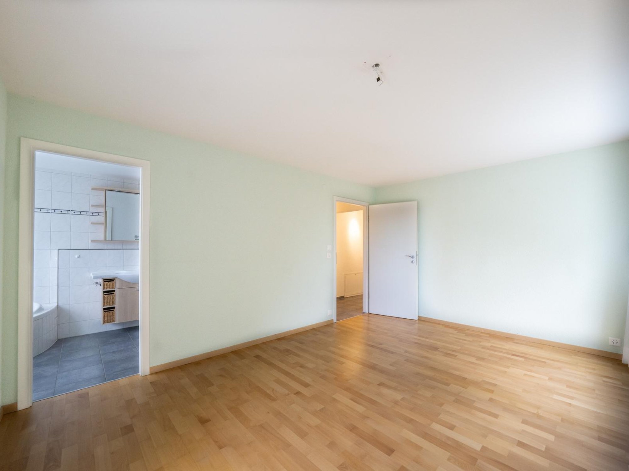 Leeres Schlafzimmer mit Zugang zum Bad