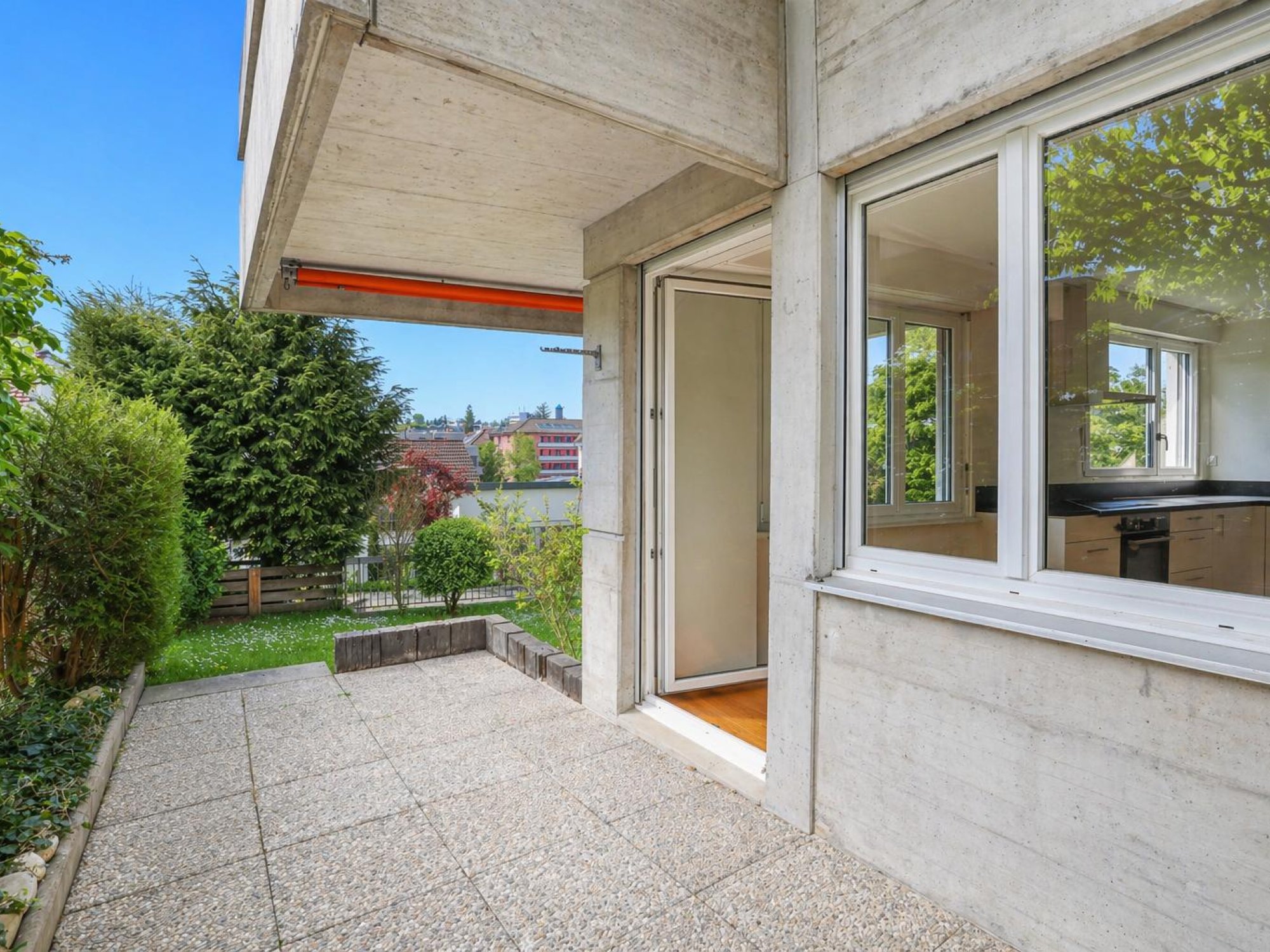 Terrasse mit Gartenblick an einem Betonbau