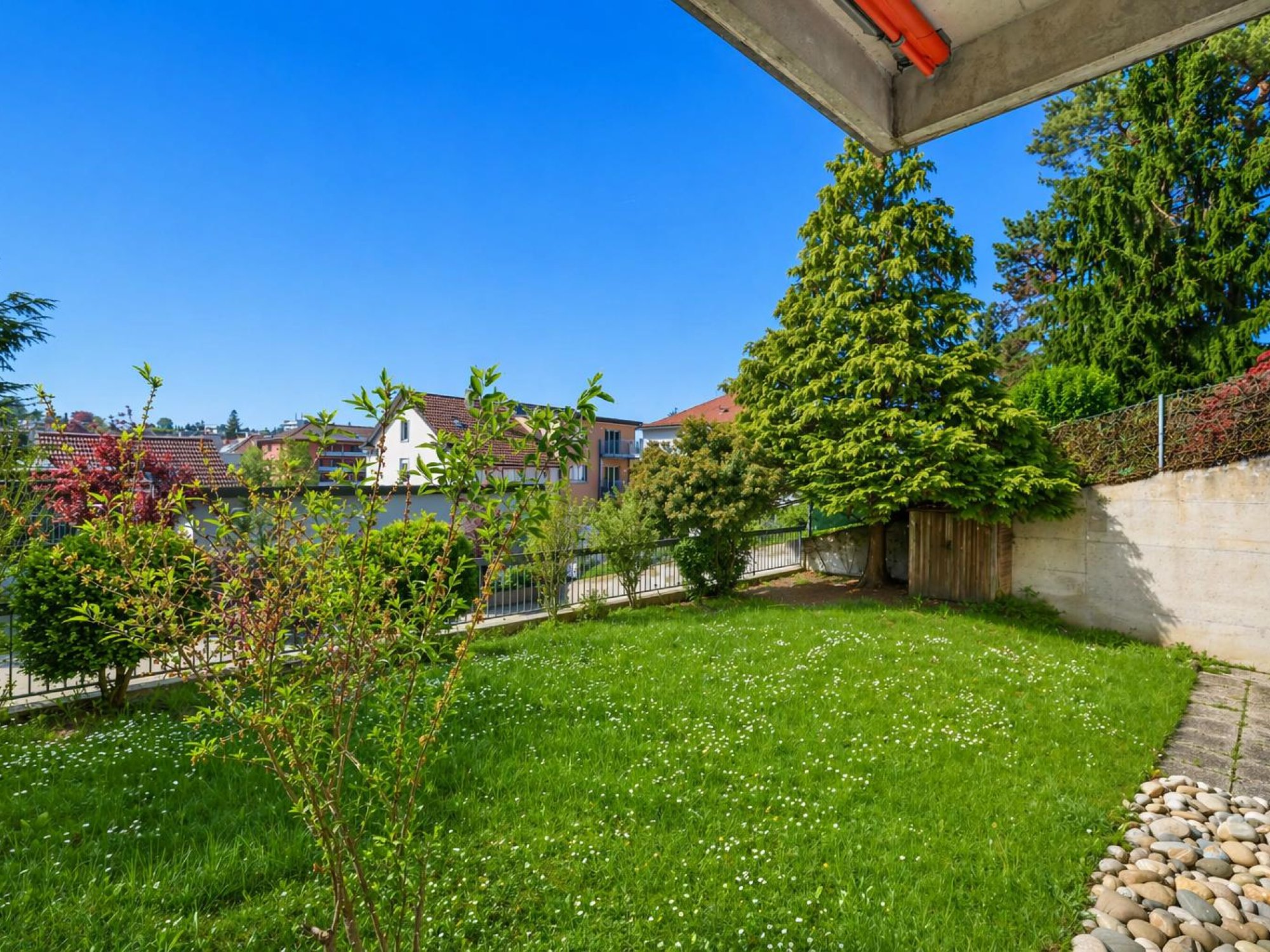 Gepflegter Garten mit Nachbarschaftsbebauung