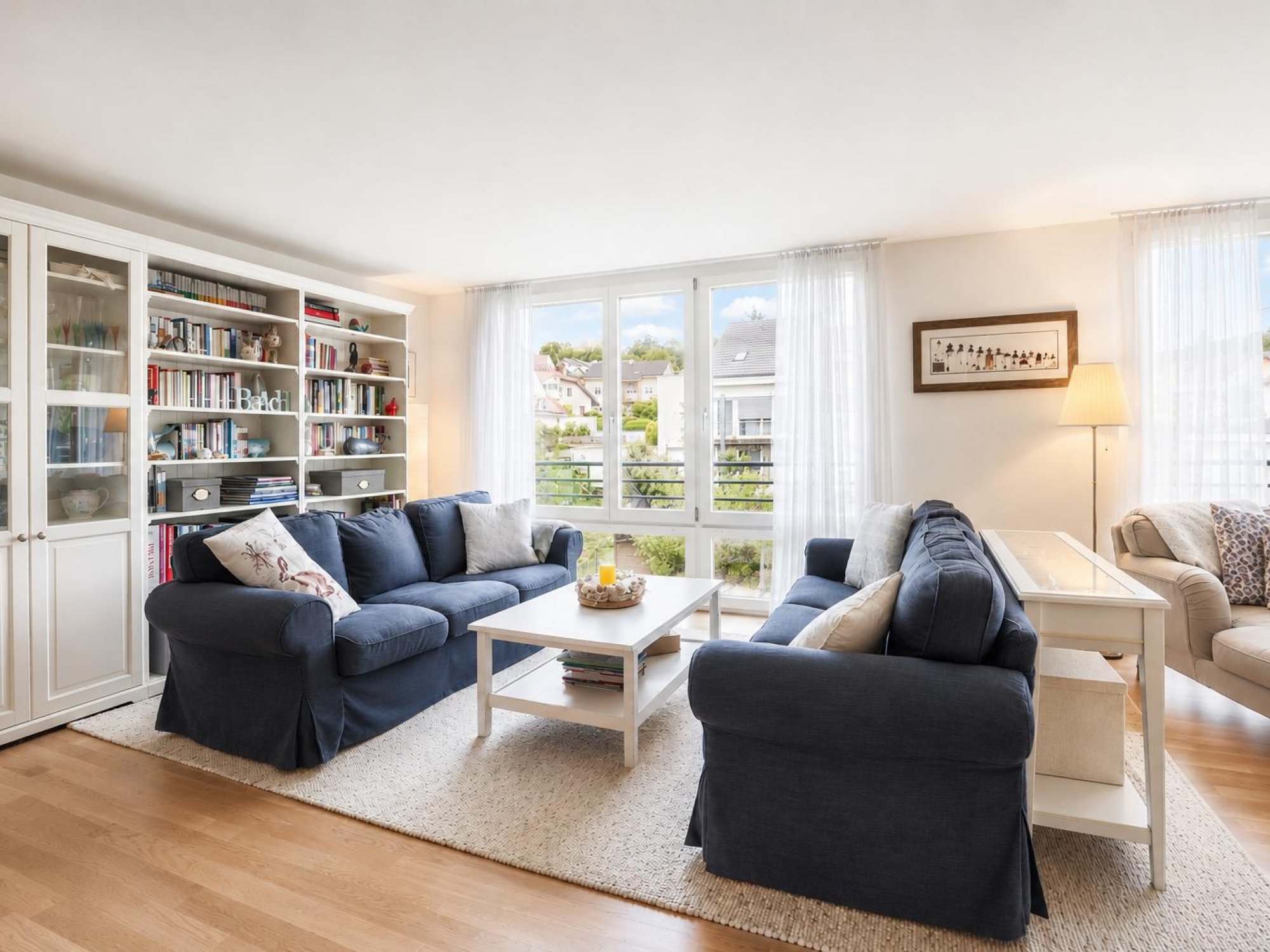 Helles Wohnzimmer mit zwei Sofas und Bücherregal