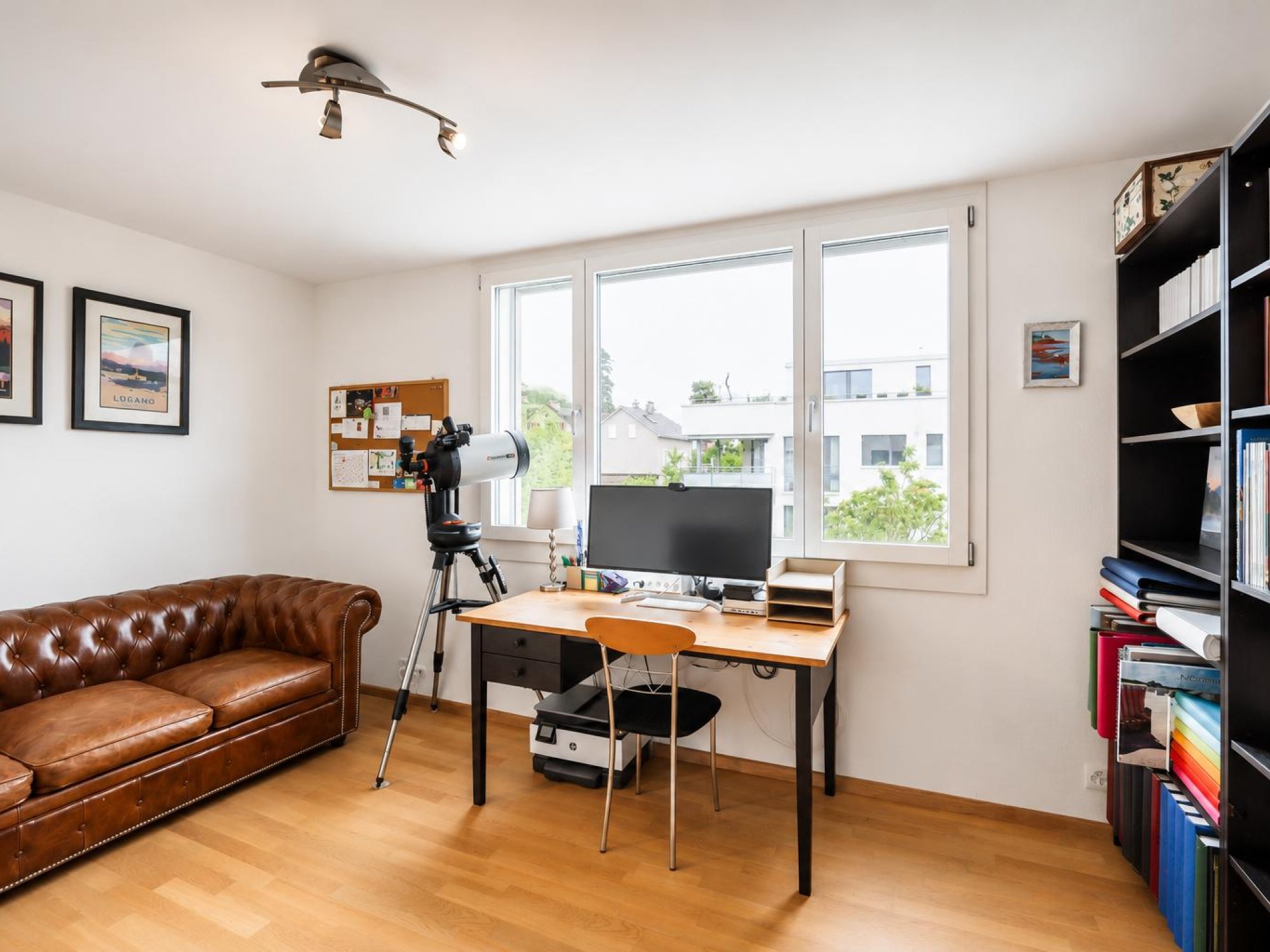 Helles Arbeitszimmer mit Sofa und Schreibtisch
