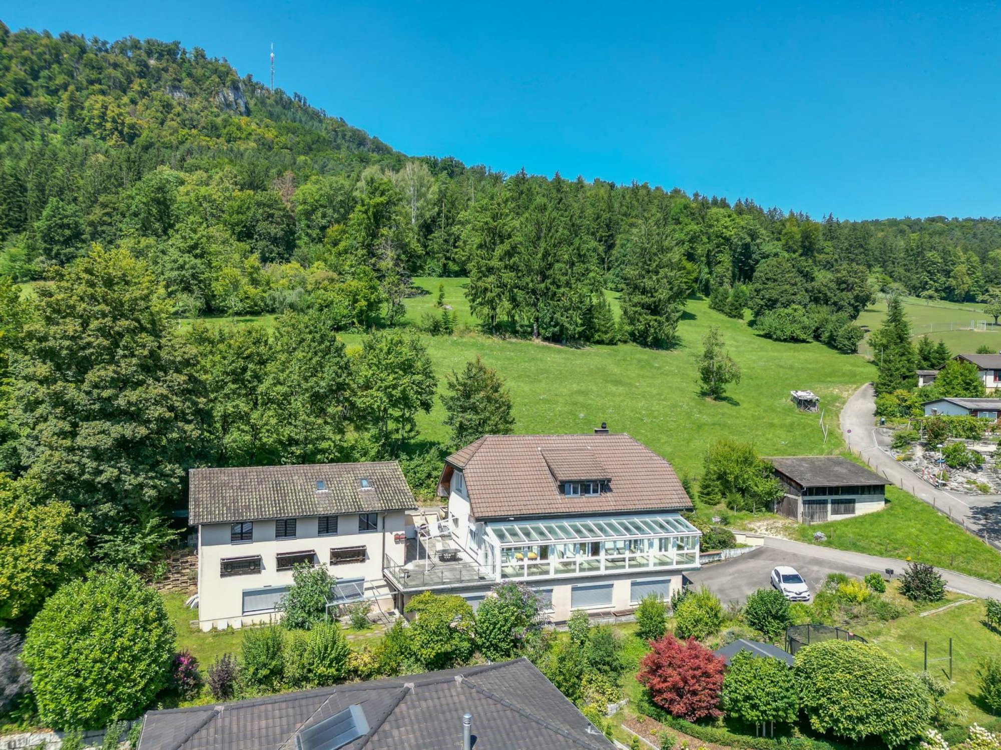 Luftaufnahme eines Hauses in grüner Hügellandschaft