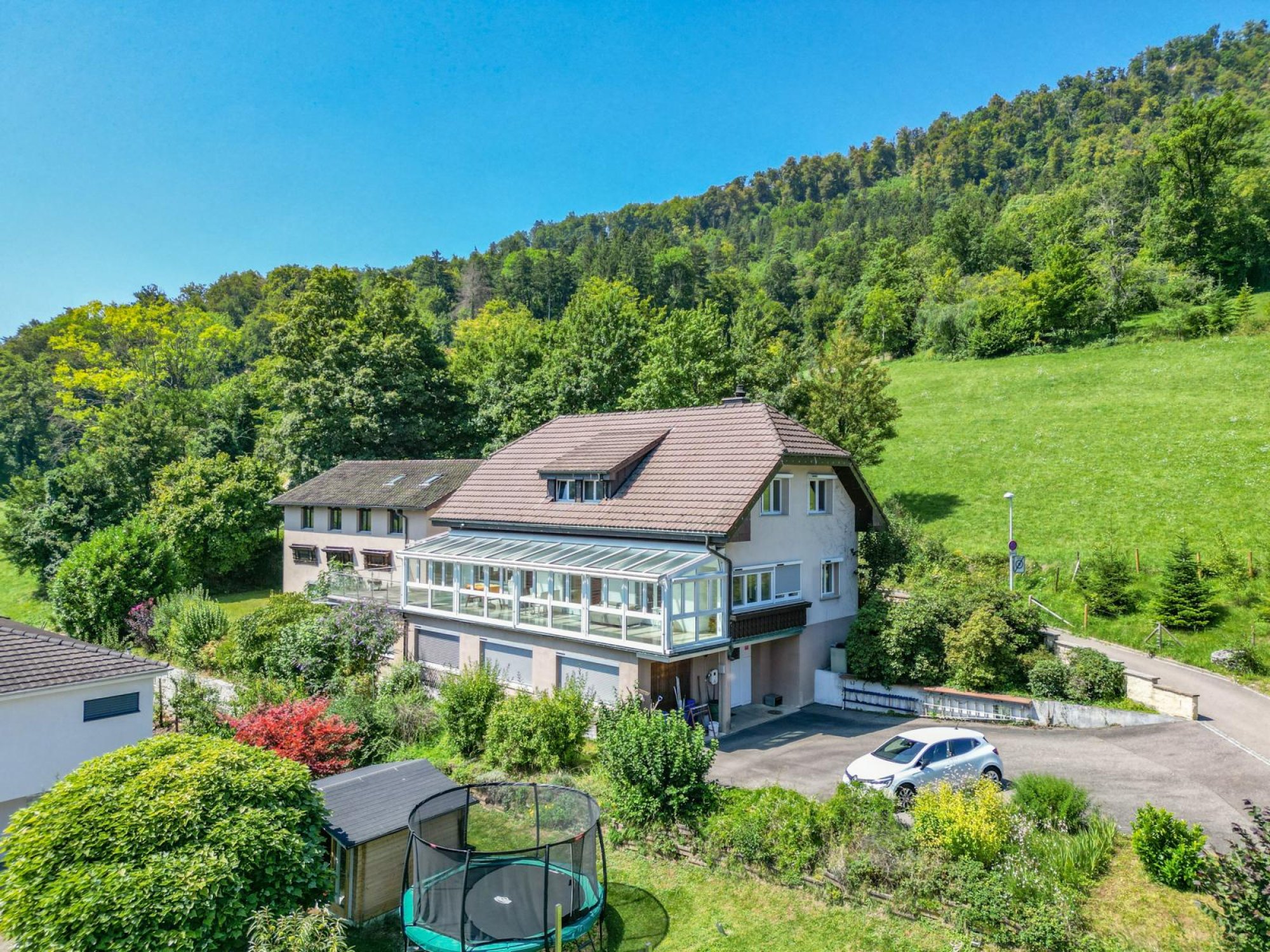 Luftaufnahme eines Hauses in grüner Hanglage