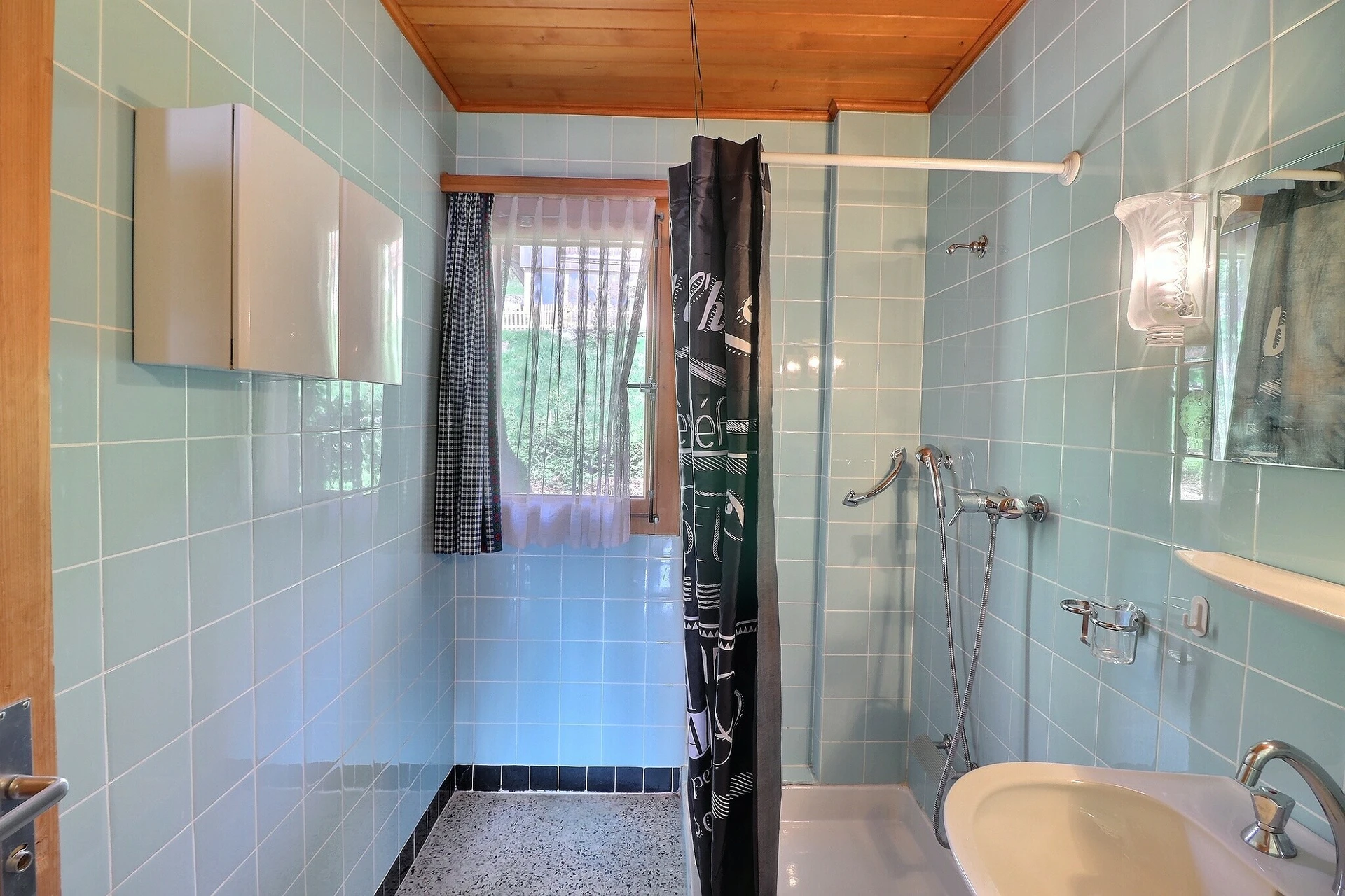 Badezimmer mit Duschbereich und Fenster