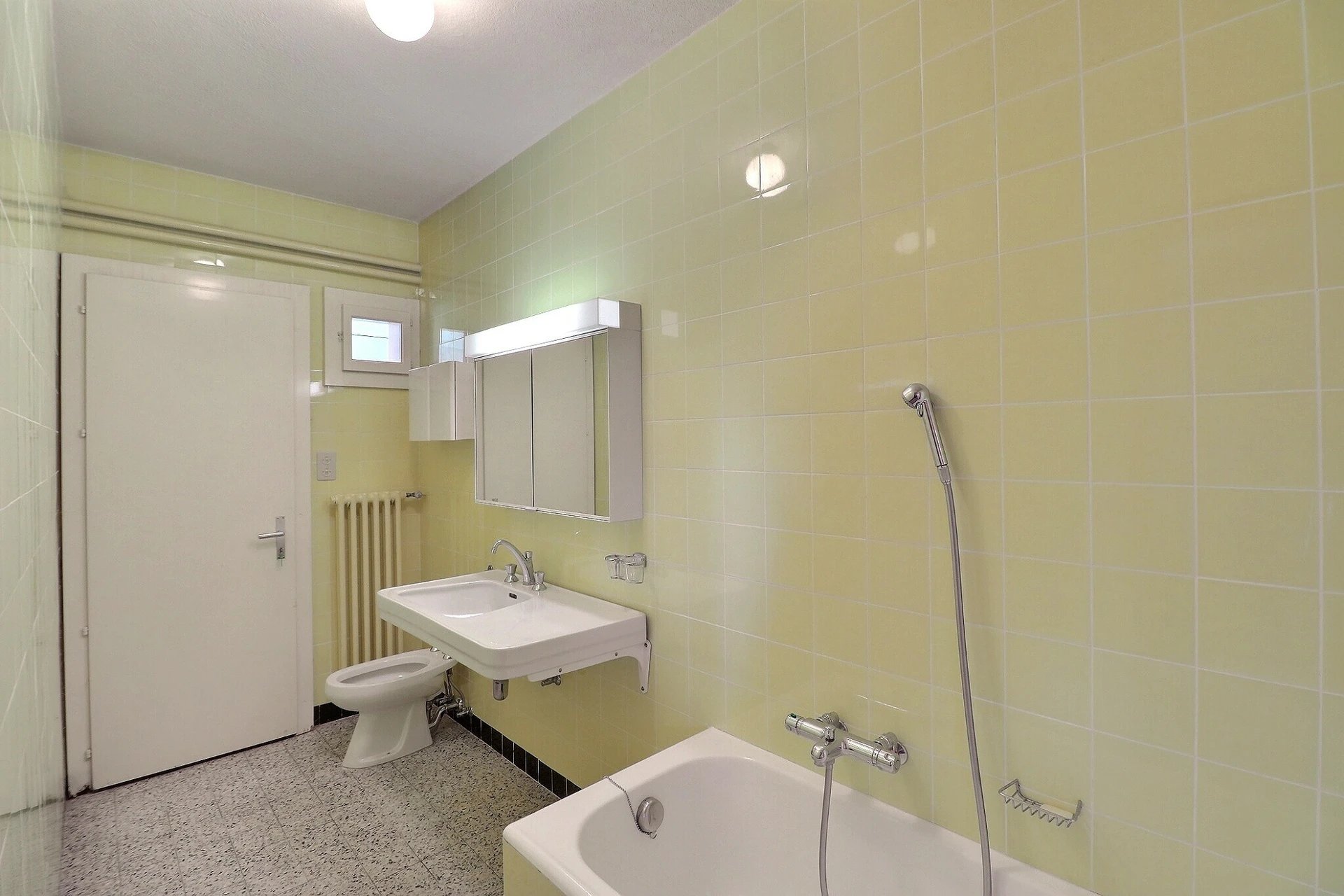 Einfaches Badezimmer mit gelblichen Wandfliesen