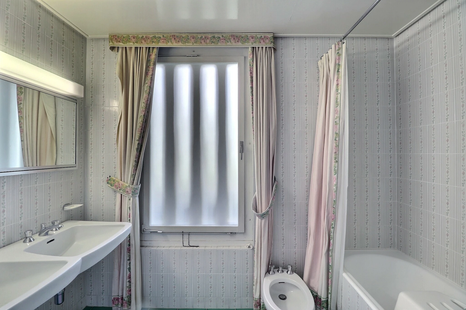 Kleines Badezimmer mit Badewanne und floralem Dekor