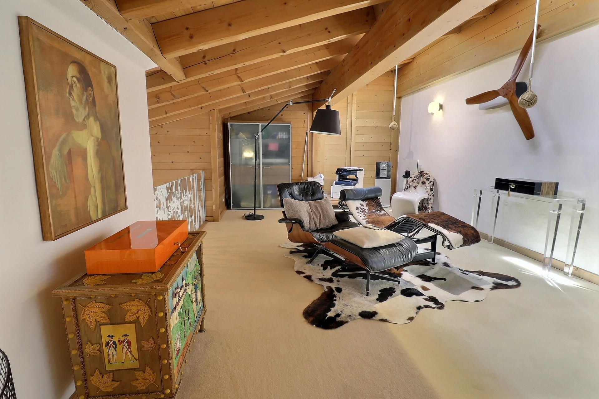 Modern eingerichteter Dachgeschossraum mit Designmöbeln und Holzbalken