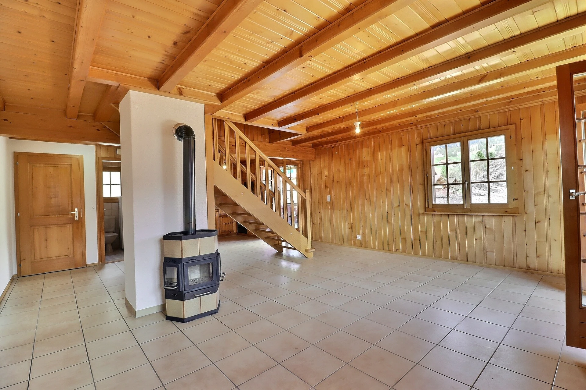 Heller Wohnraum mit Holzdecke und Kaminofen