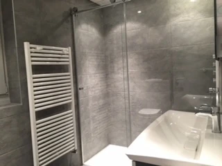 Modernes Badezimmer mit grauen Fliesen und Waschbecken