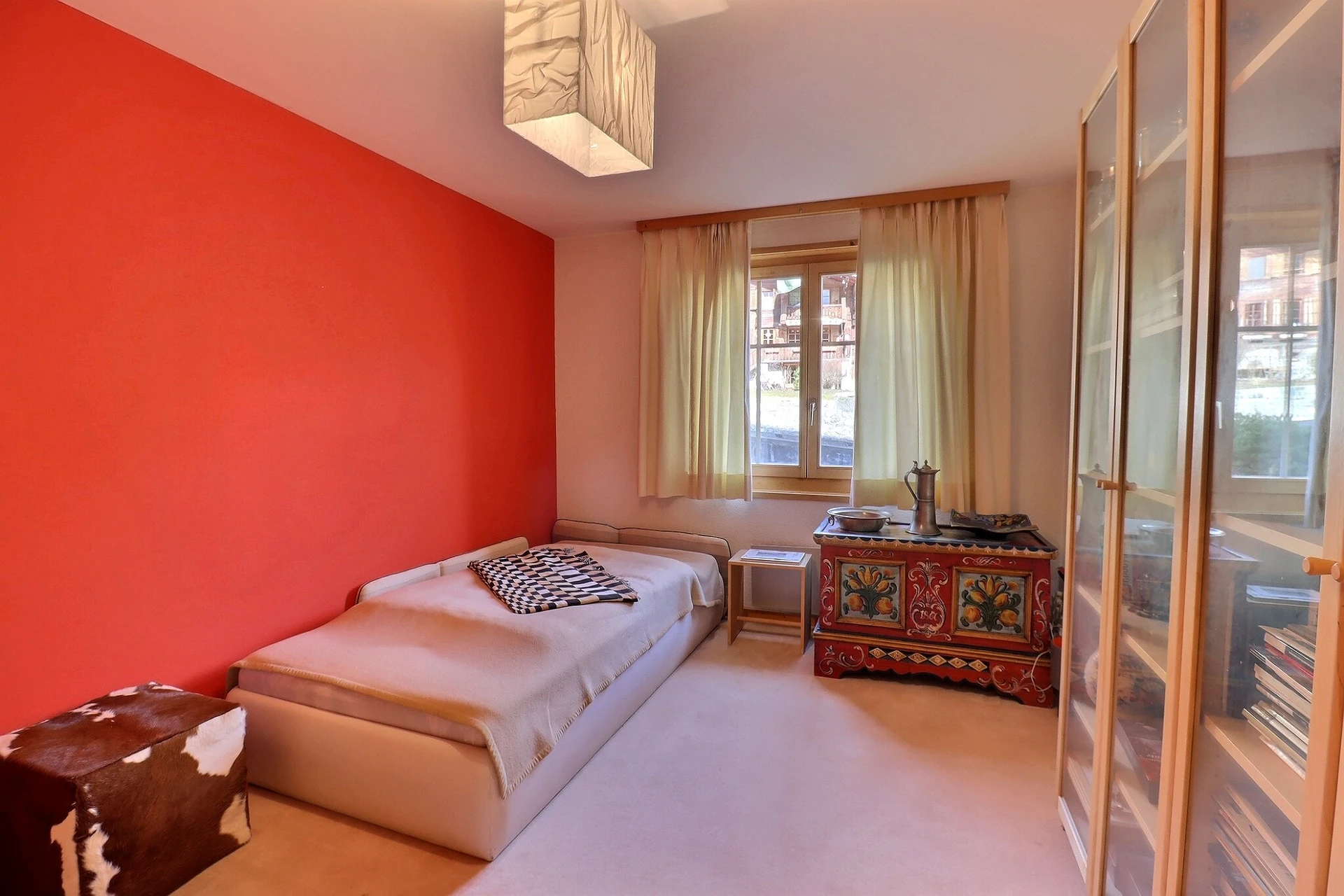 Helles Schlafzimmer mit roter Akzentwand