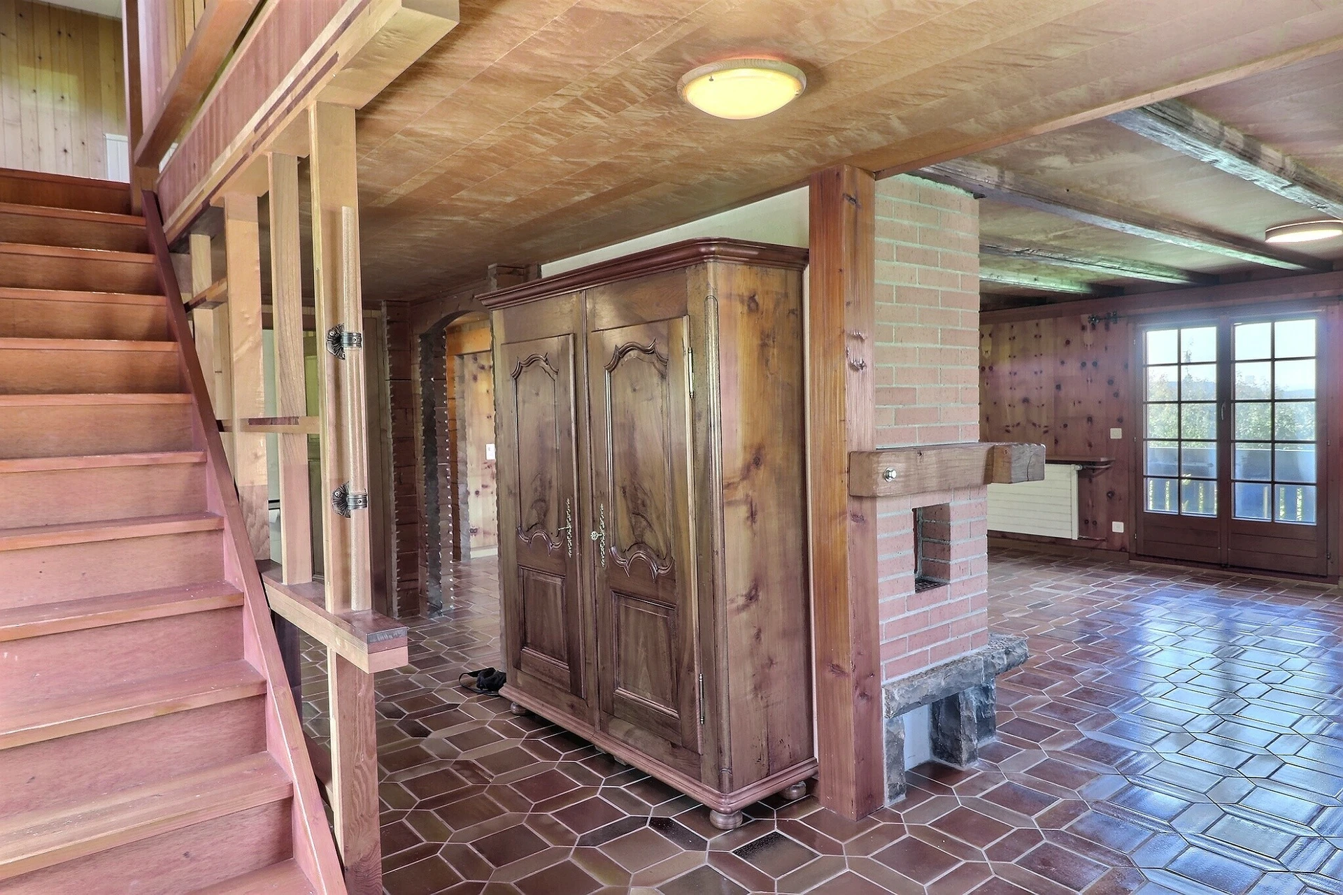 Rustikale Wohnhalle mit Treppe und Holzschrank