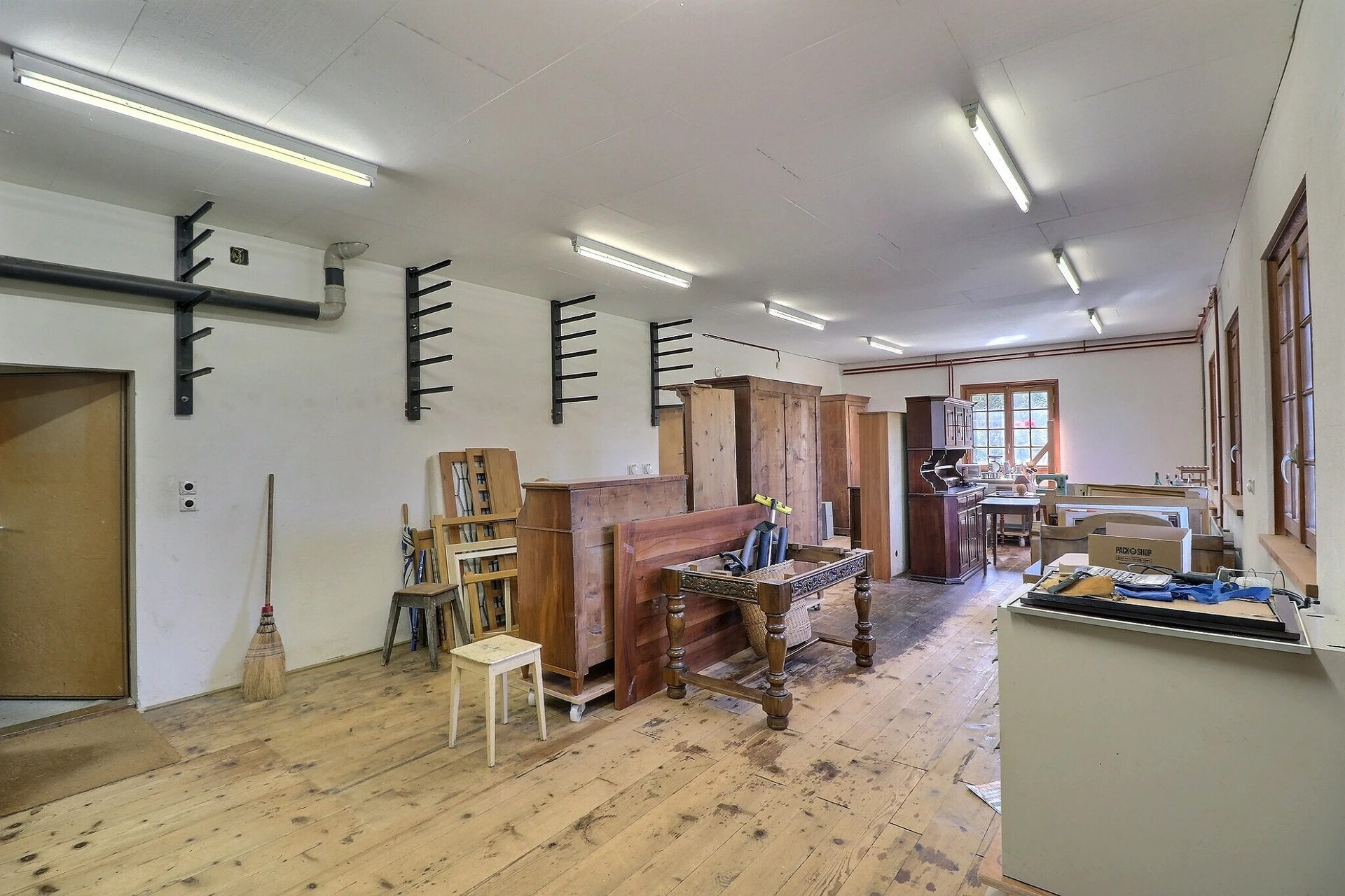 Großer Arbeits- oder Lagerraum mit Holzboden und Möbeln