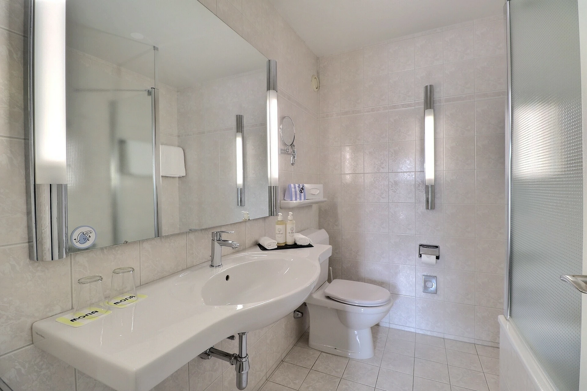 Helles Badezimmer mit Dusche, Waschbecken und WC