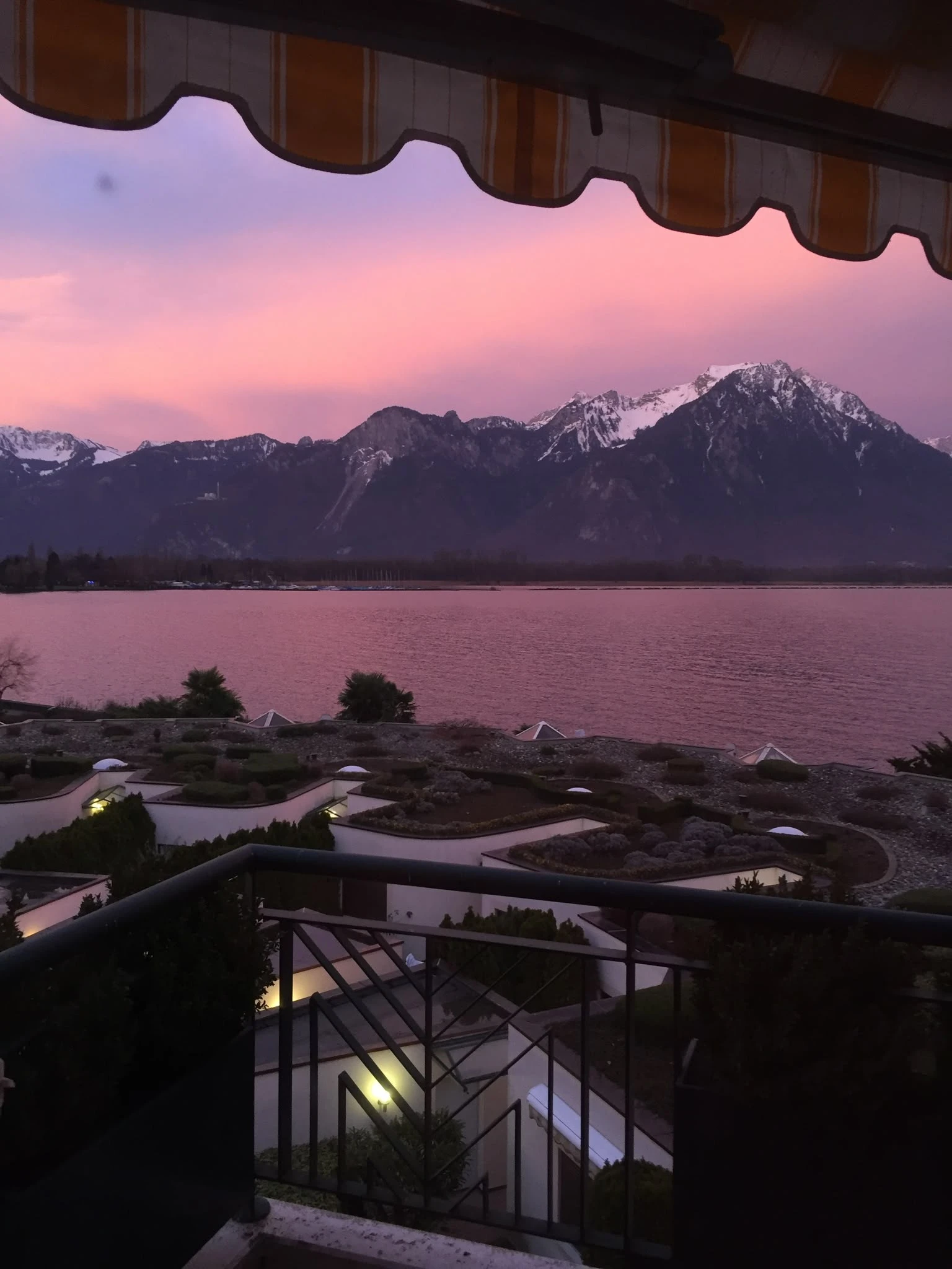 Balkonblick auf See und Berge bei Sonnenuntergang