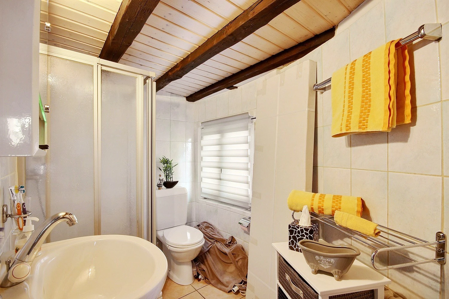 Kleines Badezimmer mit sichtbaren Holzbalken